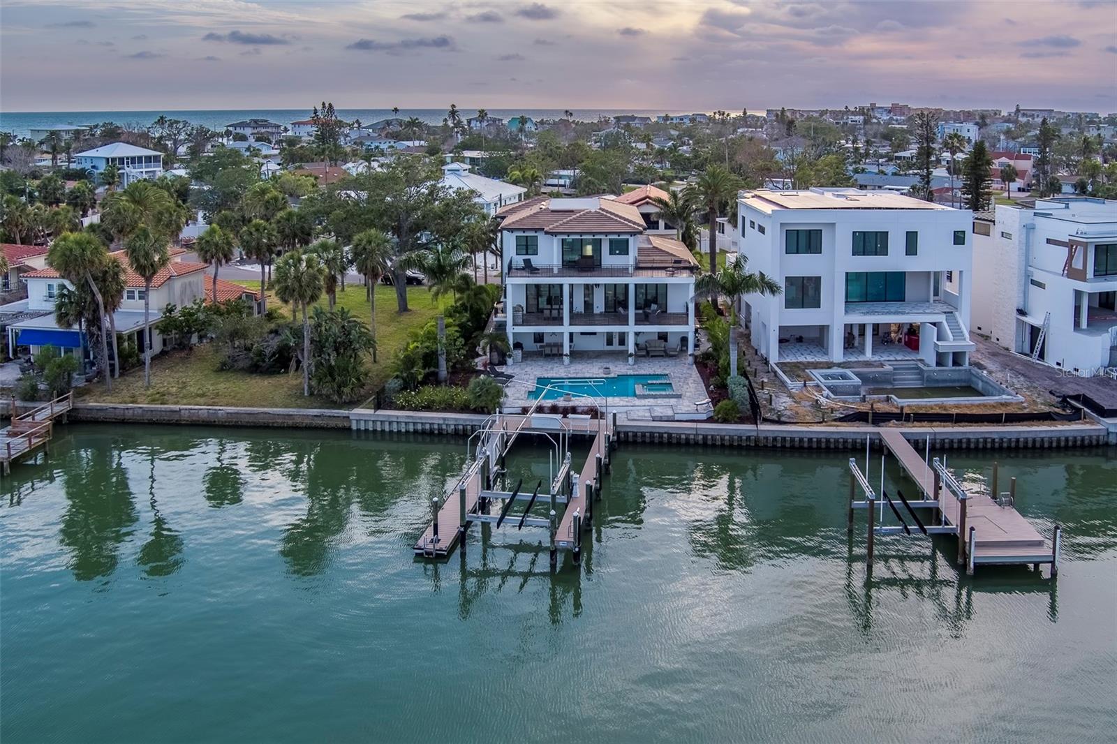$450K Under Appraised Value – Waterfront Luxury Without the Wait
Offered at $3.25M — recently appraised at $3.7M — this 2021 custom estate delivers $450,000 in instant equity. Why wait 2–3 years to build when you can own a fully completed, move-in-ready waterfront property now?
Featuring a 9,300 sq ft lot, 51’ dock with 20K lb lift, luxury pool, seawall, and high-end outdoor living — this is a rare opportunity to secure value, lifestyle, and immediate enjoyment. Replacement cost today exceeds $3.425M+.
Step into Florida waterfront living without the delays, risks, or design compromises.
A Modern Waterfront Masterpiece with Every Luxury Imaginable! Welcome to an architectural tour de force—this 2021-built, custom-designed, three-story waterfront estate is a true statement in luxury, design, and craftsmanship. Designed in collaboration with renowned MATTA Architect and constructed with uncompromising quality, this stunning 4-bedroom, 3 full and 2 half-bath residence boasts all-block construction, poured concrete floors and decks, and sleek modern detailing throughout. Step inside and be captivated by soaring ceilings, walls of hurricane-rated glass, and a seamless indoor-outdoor flow that captures breathtaking views of The Intracoastal Waterway. The heart of the home is a gourmet chef’s kitchen with large island and featuring a Thermador refrigerator with separate freezer and wine columns, a Thermador gas range, Sapphire dishwasher, and U-Line ice maker—a dream setup for culinary enthusiasts and entertainers alike. Outdoor living reaches new heights with two full outdoor kitchens with built-in natural gas grills, and an expansive waterfront oasis. Lounge beside the 30’ x 15’ heated and cooled saltwater pool and oversized gas-heated spa, accented by laminar-flow lighted fountains and dramatic natural gas fire features. Water lovers will appreciate 88 feet of massive seawall along with the 52-foot dock with a 20,000-pound boat lift, plus a floating dock perfect for launching all your water toys. Inside, enjoy the comfort and convenience of the largest residential elevator available, a huge 4-car garage with additional room for your motorcycle, bikes, golf cart or other toys! There are lots of built in speakers and the home is wired for sound throughout. Luxury abounds at every turn, from premium finishes and custom millwork to high-end Origin sliding doors opening to expansive terraces overlooking the water. Tucked in a serene neighborhood just steps from the Gulf’s sugar-white sands and close to upscale dining and nightlife, this home truly offers the best of both worlds. No detail was overlooked in this one-of-a-kind builder’s personal residence. If you're looking for coastal luxury at its finest, look no further—this waterfront masterpiece has it all." CHECK OUT THE VIRTUAL TOUR LINKS TO SEE A CUSTOM MUSIC VIDEO AND 3D TOUR FOR THIS SPECTACULAR HOME!