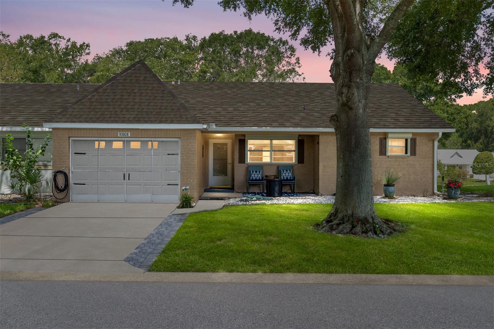 Here is the Villa you have been looking for! This is an end unit, 2 bedroom, 2 bath with lots of extras. Sit on your front porch and enjoy the beautiful open space out front! Enjoy the inside with Cathedral Ceilings and have comfort in knowing this home is very nicely updated! The HVAC with Halo Air Filtration System was added in 12/2023, new roof in 11/2023, new washer and dryer in 11/2023, new hot water heater and replumbed through the attic with new shower valve in 2023, new garbage disposal is 2025, exterior house painted in 10/2022, new garage door opener and door spring in 2022. There are custom blinds and the cabinets and mat in garage convey. There is no carpet and both bathrooms have been updated. The backyard is fenced in for your small pet to enjoy. There is also a bonus in this villa that is very unique. There is an added golf cart entrance around the back of the home with it's own roll up door. The room is under air and can also be used as a multi purpose room with an entrance from the interior or the home as well!