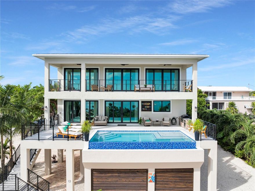 Florida Keys luxury redefined! Experience this newly constructed 2025 oceanfront masterpiece perfectly balancing coastal elegance, craftsmanship, and timeless design. With 6 bedrooms, 6.5 baths, and 3,102 sq ft under air plus 2,000+ sq ft of balconies, it offers seamless indoor-outdoor living framed by endless turquoise views. An elevated infinity-edge pool merges visually with the Atlantic beyond. Inside, a bright open floor plan captures light, air, and ocean vistas. The great room flows into a designer kitchen and dining area, creating spaces that feel both connected and serene. Each ensuite bedroom is a private retreat, beautifully scaled and positioned for comfort and privacy. See Documents Tab for a full list of luxury features. Furnished and appointed throughout showcasing ''Design by Lily,'' the interior blends beach-cottage warmth with modern Keys luxury. Custom furnishings, curated color palettes, and natural textures create a refined yet welcoming aesthetic. Every detail—from driftwood-toned floors to sculptural fixtures—exudes coastal elegance. Built by a long-time Florida Keys contractor with decades of local expertise, construction was overseen daily by the owners to ensure perfection in every finish and structure. Nothing escaped their eye, and it shows in the integrity and grace of the final result. Outdoor living shines with multiple covered terraces for dining and lounging, the infinity pool reflecting the sea, and gentle breezes completing the ambiance. Construction of the 157' dock ending in a 32' L-shaped pier is scheduled to begin in November. See Documents for plans. Newly built, fully furnished, and ready for immediate enjoyment, this residence is a rare opportunity—an oceanfront sanctuary minutes from the Marathon airport's two FBOs. Whether a private retreat or luxury vacation investment, this property embodies comfort, craftsmanship, and coastal allure.