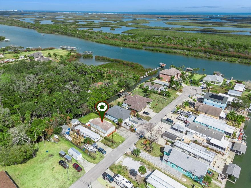 This is COASTAL WATERFRONT living at its best!  This adorable remodeled 3 bedroom, 2 bath home has a private backyard directly on a small CANAL that leads right to the Indian River, Mosquito Lagoon, Intracoastal Waterway and on to the Atlantic Ocean. Enjoy fishing, kayaking or canoeing right from your backyard!  Seawall was redone about 9 years ago and there is an electric boat davit too! The home is also on a quiet dead end cul de sac street that overlooks/ends at the Indian River.  Offering a double size driveway, a large front deck (Trex) to relax on, great room with vaulted ceilings, new luxury vinyl floors, split bedroom plan and updated kitchen and baths too!  The primary bedroom has vaulted ceilings, walk in closet, ceiling fan and a remodeled on-suite bath with double vanity and large walk-in shower.  Both guest bedrooms have walk in closets, ceiling fans - and just outside is a nice size remodeled guest bath too.  The kitchen has new Stainless Steel GE appliances, plenty of cabinets and is open to a nice dining area with sliding doors opening to the deck too. Indoor laundry room with extra cabinets for storage - and washer and dryer stay too.  Enjoy the nice size fenced yard overlooking the small canal - and appreciate the shed that offers extra storage for toys and yard tools.  The roof was put on in 2016 and the water heater is 2022.   Close to US1 and just minutes from New Smyrna Beach, this home would be a perfect year-round residence, seasonal retreat or investment rental.  Extremely low annual HOA fees too!  Don't wait - call for your private showing today!