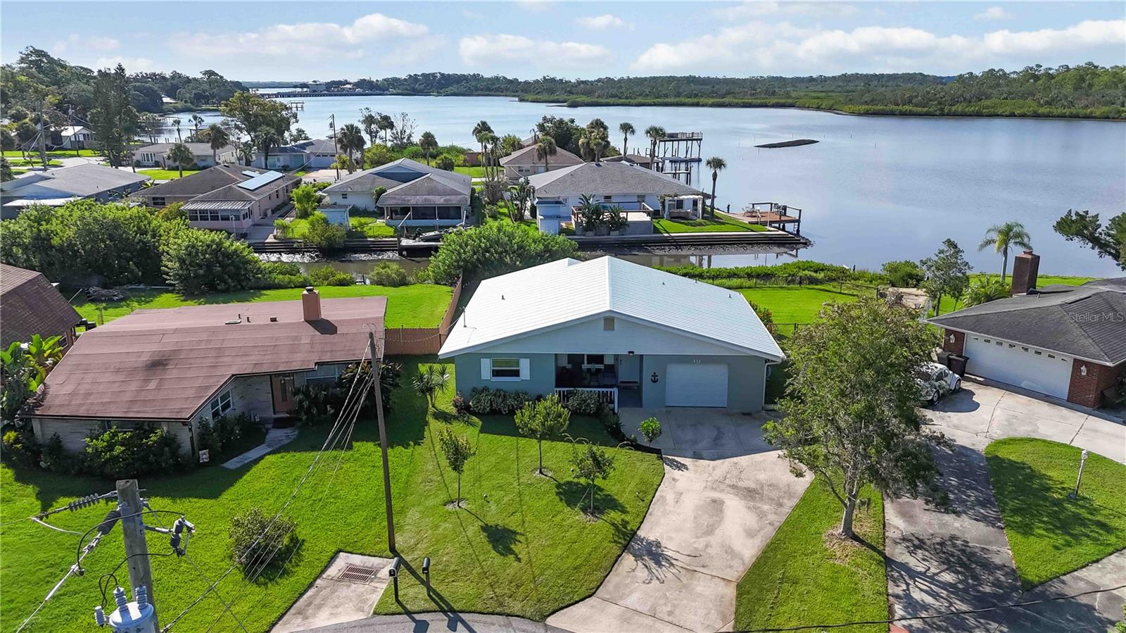 Experience waterfront living at its best in this 3-bedroom, 2-bathroom home with 1,326 square feet of thoughtfully designed space, perfectly positioned on the bay in Port Orange. With sparkling water views right in your backyard, every day feels like a getaway. Inside, the bright and airy open floor plan is designed for both comfort and style. The living area features sleek vinyl flooring that flows seamlessly into the kitchen, where you’ll find stainless steel appliances, a striking backsplash, and plenty of room to create your favorite meals. The adjacent dining room offers direct access to the porch and backyard, making it easy to enjoy sunset dinners or morning coffee with a view. The primary suite is a private retreat, complete with an en suite bath and a walk-in shower. Two additional bedrooms and a second full bath provide flexibility for guests, family, or a home office. Step outside to your beautifully landscaped, fenced backyard that backs directly onto the bay. Whether you’re entertaining friends, unwinding after a long day, or simply soaking in the waterfront scenery, this outdoor space is designed to impress. Ideally located just minutes from popular restaurants, shopping, and the area’s renowned beaches, this home combines everyday convenience with the ultimate coastal lifestyle. Mortgage savings may be available for buyers of this listing.
