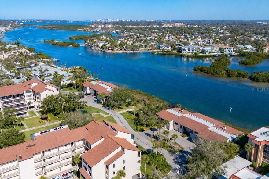Offered for the first time, this rare three-bedroom, three-bath waterfront villa at Excelsior’s coveted Beach-to-Bay community presents an exceptional opportunity to own one of only eight residences of its kind. Positioned at end of the property along the Intracoastal Waterway, the villa enjoys extraordinary privacy, peacefulness, and sweeping 180-degree water views from the expansive 36-foot lanai and most principal rooms. This light-filled corner residence lives beautifully like a single-family home, elevated above a private two-car garage and framed by windows on three sides. The open floor plan is spacious and airy, enhanced by vaulted ceilings in the living room, primary suite, and guest bedroom, hardwood flooring, and sliding glass doors that invite the waterfront setting indoors. A wood-burning fireplace adds warmth and character, while ceiling fans, custom window treatments, and 3M hurricane film on windows provide comfort and peace of mind. The updated kitchen opens seamlessly to the main living areas, creating an ideal space for entertaining or relaxed island living. The primary suite features a walk-in closet, walk-in shower and updated bath. A new HVAC system, in-residence washer and dryer, and thoughtful upgrades throughout add to the villa’s move-in-ready appeal. Excelsior’s villas are uniquely situated directly on Sarasota Bay’s Intracoastal Waterway, with no other residences between you and the water. Only eight villas exist in total, four three-bedroom residences and four two-bedroom villas, making this a limited opportunity. Residents of Excelsior enjoy an unparalleled resort lifestyle with deeded beach access to Siesta Key’s world-renowned white sands, turquoise Gulf waters and mango-colored sunsets. Amenities include two large, heated pools, two hot tubs, tennis and pickleball courts, shuffleboard, a fitness center, library, community room, and tranquil tree-lined walkways with ponds and fountains. The fishing and lounging pier, grilling areas and picnic spaces are just moments away. The community is pet-friendly (small dogs), offers easy access to South Bridge and a short distance to Crescent Village, with free trolley service to Siesta Village. With two-week minimum rental policy and on-site property management services available, the residence also offers attractive flexibility for seasonal or investment use. From morning experiences along the shoreline to breathtaking sunsets over the Gulf, every day on Siesta Key feels like a vacation. And when you're ready to explore beyond the island, downtown Sarasota is just a short drive away, offering world-class dining, arts and culture, including the Ringling Museum, Van Wezel Performing Arts Hall and St. Armands Circle. Rarely available and exceptionally positioned, this waterfront villa captures the best of Siesta Key living, privacy, views, resort amenities and effortless access from beach to bay.