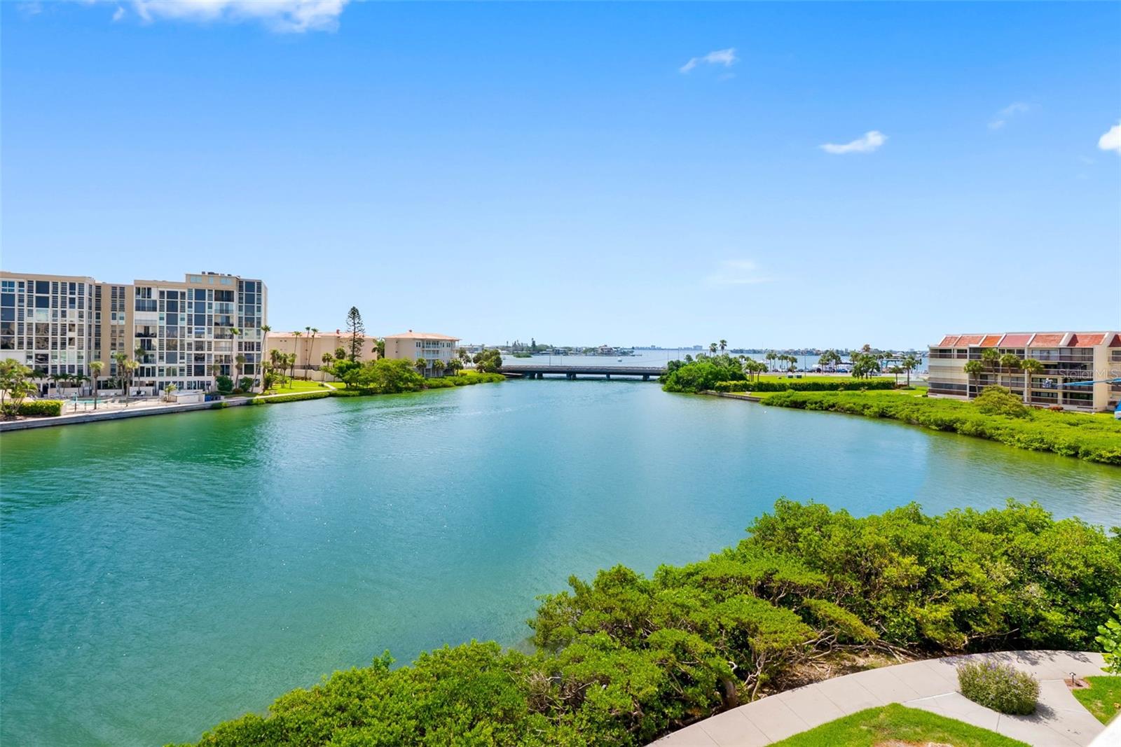One or more photo(s) has been virtually staged. Beautiful, beautiful views from this top 4th floor 2 BR 2 BA corner unit in the Savannah Bldg. in HarbourSide. This very spacious 1,445 sq. ft. condo is one of the largest floor plans on the island. The oversized balcony, with its exceptional southerly view all the way to Isla, is perfect for outdoor dining and entertaining. The living area has new luxury vinyl plank flooring throughout and neutral wall colors. The kitchen has a private dining area. Both the primary bedroom and the guest bedroom are extra spacious (16’ x 15’) and both have walk-in closets. The primary bedroom has balcony sliders and a view of the intracoastal and the marina and includes an ensuite bath. The split bedroom floor plan includes a large inside laundry room with full size washer and dryer. Covered parking space #13 is steps from the building entry. AC in 2019. Savannah building and carports have been freshly painted, a new roof installed in 2024, and elevator recently renovated.It has passed the Milestone inspection and the SIRS review. Community Highlights include 24 Hour Guard-Gated, pet-friendly, all-ages island community, 6 pools (the Savannah Association enjoys use of the Clubhouse pool, largest of the 6), 5 tennis courts with pickleball, saunas, hot tub, his & her fitness centers and a country club style clubhouse with active social calendar, a 1.5-mile waterfront walking trail, 3 car wash stations, kayak storage, and an 87-slip marina, electric vehicle charging stations, shuffleboard, and more. Just minutes to beautiful beaches, shopping, restaurants, healthcare, downtown St. Petersburg, major sports venues, airports, and even Disney World. Welcome to HarbourSide — close to everything, yet a world away!