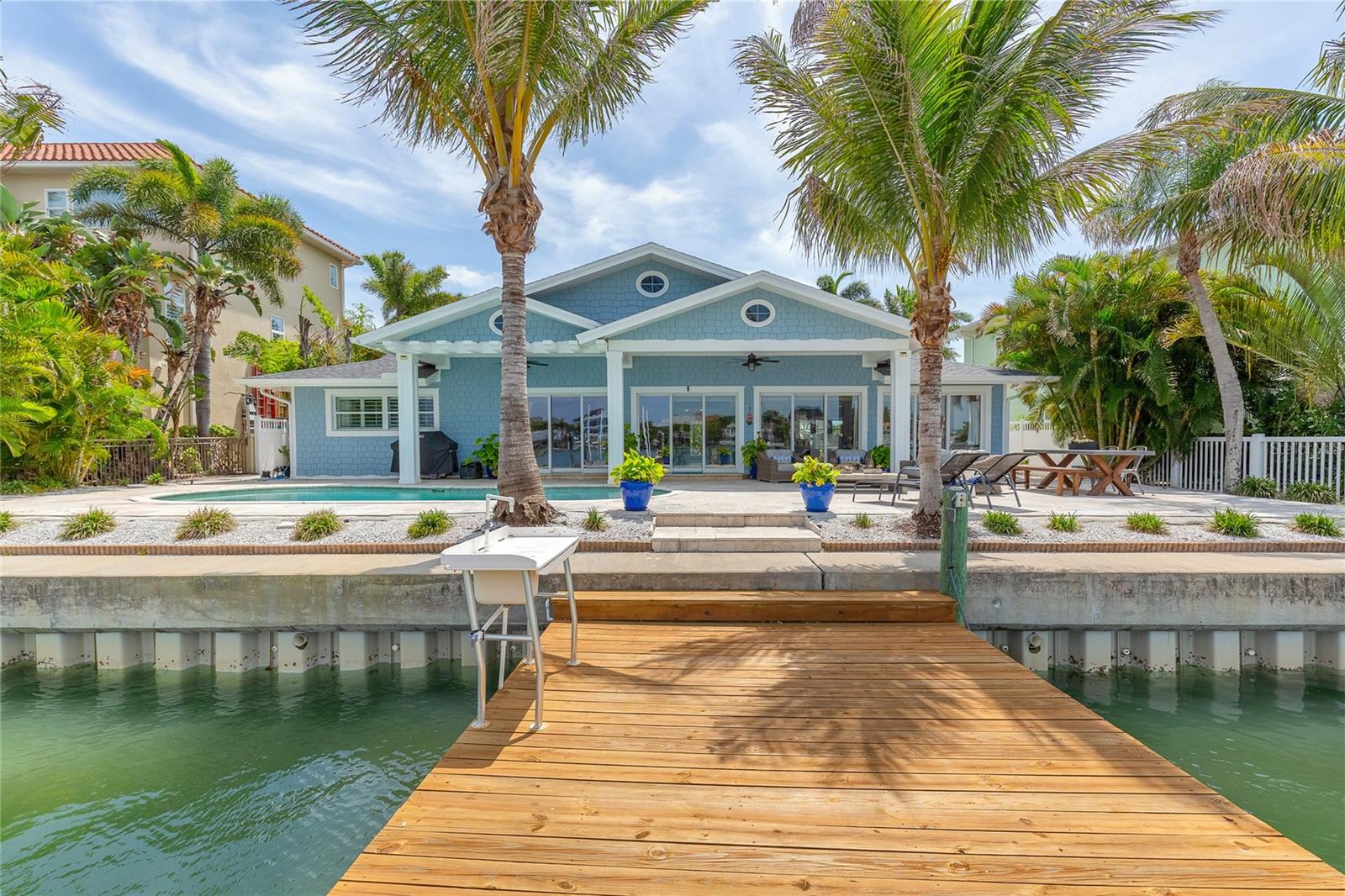 Coastal Craftsman Belleair waterfront home with a sparkling view of the intracoastal featuring deepwater dock with 40ft+ boat slip and 19,000 lb lift. This Belleair three bedroom, two bathroom plus office features new roof, gutters, new paint and new wood look, large format porcelain tile floors. Remodeled with an open floor plan and coastal-style tongue and groove 10 foot high vaulted ceilings. The gorgeous kitchen features beautiful quartz countertops, KitchenAid stainless-steel appliances and a large center island perfect for entertaining. Gas appliances including a tankless water heater. The kitchen opens to a formal living room with a gas fireplace and custom built-in shelves on either side. The primary suite has a large walk-in closet and the primary bath features a free- standing porcelain tub and separate glass enclosed shower. This split plan layout has two bedrooms that share a bathroom with dual sinks and a jetted bathtub. A study nook between the bedrooms can be used as a tech area. The backyard oasis features a covered lanai, heated saltwater pool with fountains, Travertine paver deck and lush landscaping. The home is situated t in close proximity to the Belleair Country Club, The Pelican Golf Club, Dimmitt Community Center and several fine dining options all within a short golf cart drive away. Absolute move-in condition--this one is a must see!