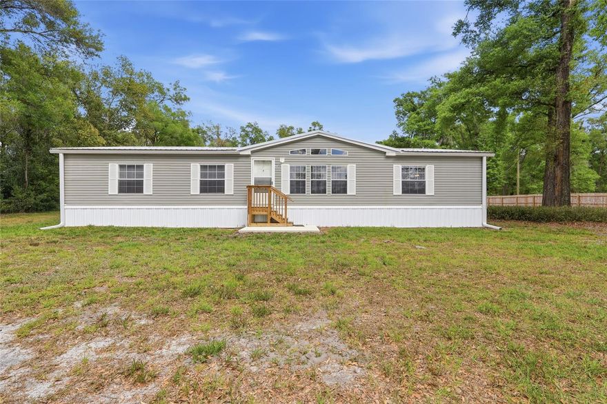 Tucked away from the hustle and bustle, this private 1.2-acre retreat offers the peaceful lifestyle you’ve been searching for. This well-maintained 2003 manufactured home features 3 bedrooms, 2 baths, and a split floor plan, with every bedroom offering its own walk-in closet. The spacious kitchen features an island and abundant cabinet space, connecting to the dining area and leading into a cozy living room anchored by a wood-burning fireplace. You’ll also love the convenience of an inside laundry room and a generator hookup for added peace of mind. Step outside and enjoy your own slice of country living complete with a pineapple orchard, two storage sheds, and a large open lot with plenty of room for your RV, boat, or toys. A 6-ft privacy fence lines two sides of the property, adding to the sense of seclusion, while the west-facing setting delivers stunning sunset views. Enjoy the best of both worlds with quiet, spacious living and easy access to everything you need just a short drive to Tampa, Wesley Chapel, Plant City, Lakeland, and I-4. Plus, Florida’s award-winning Gulf Coast beaches, shopping, dining, entertainment, and world-famous theme parks are all within reach.