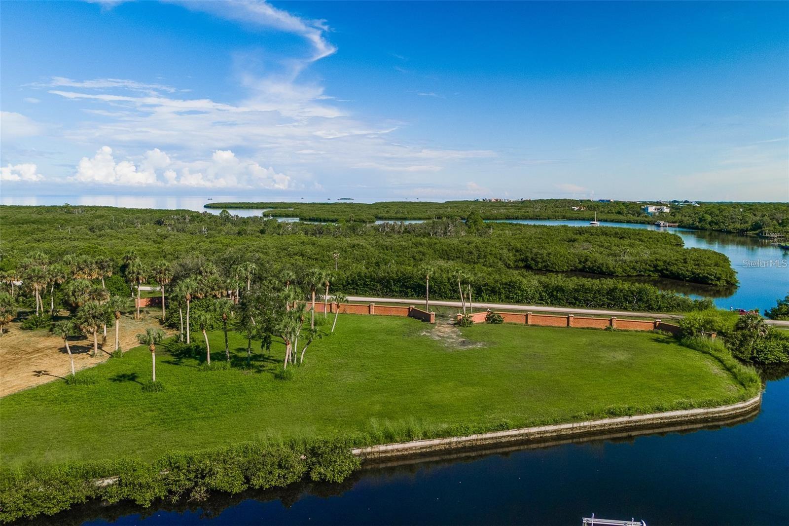 Re-Priced to sell!!! don't miss the opportunity to have a rare waterfront lot with a generous size of 1.54 Acre!! There is nothing else like it in the area! Waterfront lot of this size does not come along very often; the possibilities are endless in this stunning lot consisting of big acreage in combination with a deep-water canal straight to the Gulf of Mexico with no bridges or other obstructions. Why settle for an older home when you have a golden opportunity to build your home with the exact specifications that you've always envisioned. This oversized lot is zoned ER (Estate Residential) in a small subdivision with only 6 Home-sites all security and private brick fenced, each lot has a private gated entrance. The seller started the construction of a dock by putting 7 dock pilings and the buyer can finish building a huge dock with water & electricity on those 330 feet of seawall room for all your water toys. Take advantage of existing survey, geotechnical report, and a completed set beautiful architectural plan home or come up with your own design. No HOA, no CDD, you can bring your own builder, or we can recommend one. Live in the serenity and seclusion surrounded by Boy Scout Preserve with a boardwalk nature trail, incredible water views and the Robert K. Rees Memorial Park is just down the road providing a beautiful sandy beach where you can sunbathe, swim, fish, watch magnificent sunsets. Centrally located with easy access to US Hwy 19 a major North-South connector and close to revitalized downtown with great restaurants and entertainment. Come and fall in love with a property like this...build your waterfront dream home and start enjoying the Florida lifestyle!! *One of the owners holds an active Real Estate License*