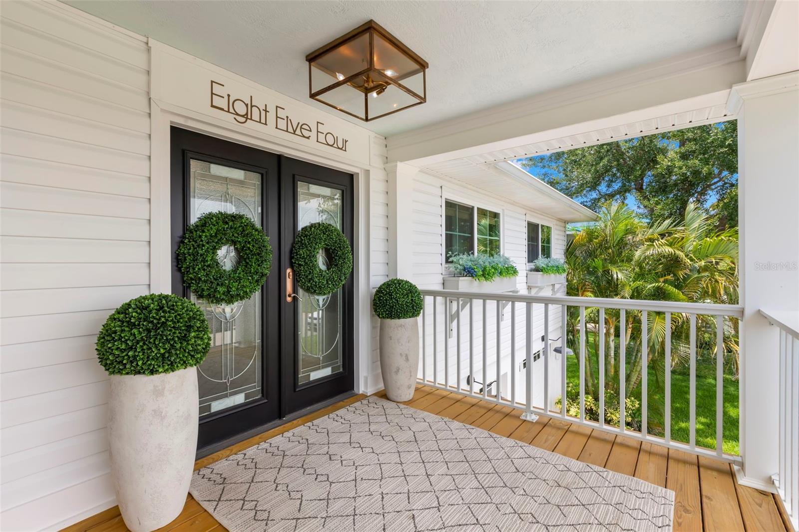 Welcome to your coastal retreat in beautiful Tierra Verde. This stunning 4-bedroom, 3.5-bathroom home seamlessly merges modern upgrades with inviting warmth. Upon entry through the elegant leaded glass French doors, you will be greeted by vaulted ceilings and a spacious open great room with new wide plank white oak hardwood flooring. A custom fireplace with a reclaimed wood mantle and an antique chandelier from a historic St. Petersburg hotel infuse the space with distinctive charm and high vaulted ceilings complemented by a reclaimed wood ceiling beam. The thoughtfully designed kitchen features quartz countertops, white cabinetry, stainless steel appliances, a custom wood hood surround, and updated lighting that combines style with functionality. The master suite offers a tranquil escape, complete with a marble-floored master bath, a new vanity, and a spacious walk-in closet. The lower level is equipped with durable LVP flooring and a practical kitchenette featuring butcher block countertops and floating shelves. Step into your own private oasis, featuring an impressive two-story screen enclosure that surrounds a stunning pool, perfect for both relaxation and entertainment. This serene outdoor area is enveloped by lush, mature tropical landscaping, offering an exceptional level of privacy and tranquility. Whether you're enjoying a quiet morning swim or hosting a lively gathering, this exquisite backyard is a true retreat, blending luxury with nature's beauty.