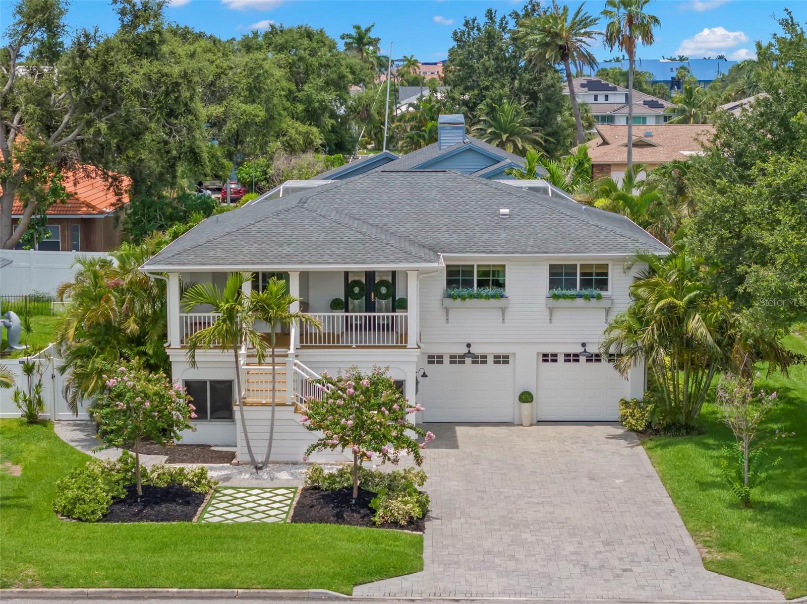 Welcome to your coastal retreat in beautiful Tierra Verde. This stunning 4-bedroom, 3.5-bathroom home seamlessly merges modern upgrades with inviting warmth. Upon entry through the elegant leaded glass French doors, you will be greeted by vaulted ceilings and a spacious open great room with new wide plank white oak hardwood flooring. A custom fireplace with a reclaimed wood mantle and an antique chandelier from a historic St. Petersburg hotel infuse the space with distinctive charm and high vaulted ceilings complemented by a reclaimed wood ceiling beam. The thoughtfully designed kitchen features quartz countertops, white cabinetry, stainless steel appliances, a custom wood hood surround, and updated lighting that combines style with functionality. The master suite offers a tranquil escape, complete with a marble-floored master bath, a new vanity, and a spacious walk-in closet. The lower level is equipped with durable LVP flooring and a practical kitchenette featuring butcher block countertops and floating shelves. Step into your own private oasis, featuring an impressive two-story screen enclosure that surrounds a stunning pool, perfect for both relaxation and entertainment. This serene outdoor area is enveloped by lush, mature tropical landscaping, offering an exceptional level of privacy and tranquility. Whether you're enjoying a quiet morning swim or hosting a lively gathering, this exquisite backyard is a true retreat, blending luxury with nature's beauty.