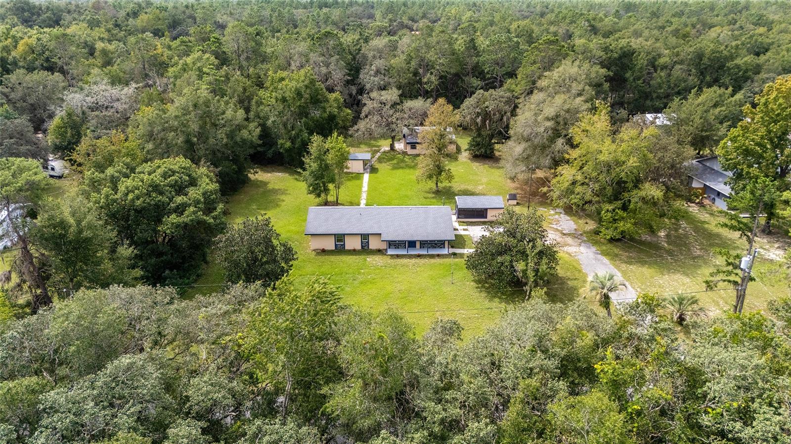 Discover this delightful, updated 3-bedroom, 1 1/2 bath home situated on a serene 1.25-acre lot. This inviting property seamlessly blends modern enhancements with tranquil surroundings, making it your perfect Florida getaway. This home features thoughtful upgrades, like a completely remodeled kitchen, tastefully updated bathrooms, and luxury vinyl plank flooring throughout. A new HVAC was installed on the main home, and a roof was installed on the Main Home and external buildings in 2021. The expansive lot includes additional structures that provide versatile opportunities waiting for your creative touch — perfect for a greenhouse, workshop, storage, or the potential conversion into a mother-in-law suite. Whether you seek space for hobbies, guests, or future expansion, this property offers ample room to grow. This home is also centrally located, allowing you to experience the best of both Citrus and Marion Counties. Here, you can indulge in excellent dining, shopping, and entertainment, as well as enjoy boating and fishing along the chain of lakes or explore miles of walking and biking paths along the Withlacoochee Trail. Conveniently located just a short drive from Dunnellon, Crystal River, and Ocala, this location provides you with quick access to outdoor adventures and daily necessities. This home strikes the perfect balance between tranquility and convenience that you’ve been searching for. Schedule your appointment today to learn more!