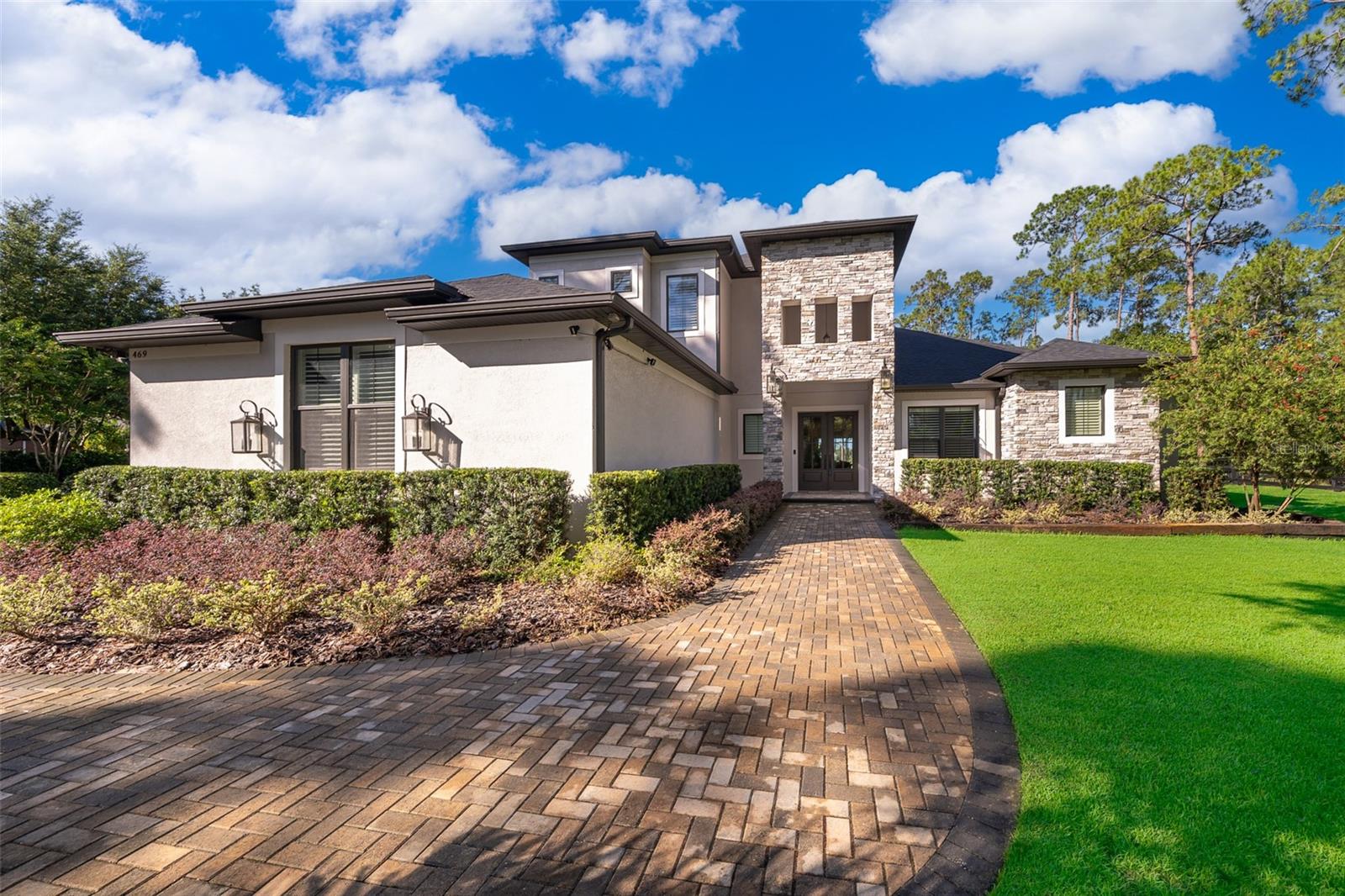 A rare opportunity presents itself with this masterpiece custom built 5 Bedroom, 4.5 Bath, pool home in the gated equestrian community of Seminole Woods. Situated on one of the premier lots, you will enjoy panoramic lake views of Island Pond, a scenic 54-acre natural lake which is great for fishing, canoeing, or small boats (NO gas-powered engines to interrupt the tranquility). Take a stroll down your NEW dock to enjoy a beverage while relaxing and being surrounded by nature’s beauty. The views from the rear of the home and dock are truly amazing. As you approach the main entry you will see and feel the excellent quality of construction which starts with a beautiful double-door-leaded glass entry way. The foyer has cathedral ceilings and opens to the living room which is a showcase of highly skilled craftmanship with exposed beamed ceilings, extensive crown moldings, custom trim work, along with functional built ins. The floor coverings throughout all of the main living areas are beautiful, engineered hardwood with high end tile in the wet areas. The gourmet kitchen is a chef's dream w/ an enormous center island, a 48 inch Thor brand gas range & cooktop with a griddle, dual electric ovens, a pot filler which is built in above the range, large farm sink, a commercial size refrigerator, a dedicated coffee serving area with butcher block counters tops, and gorgeous Quartzite counter tops throughout the remaining areas. The floor plan of this home is ideal as a true split plan with the primary bedroom & bathroom occupying the entire west side of the home. The primary suite is a retreat of perfection with a spacious sitting area along with double french doors that open out to the lanai, summer kitchen, and pool. There are two large walk-in closets with custom built in closet organizers and the primary bath has an elegant spa-like feel with an oversize shower, stand-alone soaking tub, and gorgeous granite counters. The kitchen, dining, and living areas all flow perfectly and have direct views of the pool & lake which can all be accessed by stackable sliders. The den or home office is just off the foyer & entry which provides for a quiet and separate space. In addition to the 5 bedrooms and the den / office there is a dedicated flex room that currently functions as an exercise room and is strategically placed near the garage entry. At the garage entry there is also a drop area with another custom built-in perfect for shoes, coats, backpacks, etc. The remaining 3 additional downstairs bedrooms occupy the entire east side of the home with a jack and jill bathroom servicing two of the bedrooms. The 5th bedroom is located upstairs where you will also find a huge recreation room, loft, and the 4th bathroom. All of the bedrooms have custom closet organizers for added storage efficiency. The upstairs recreation room has a built-in wet bar and the possibilities of different uses for this area are endless. The driveway has an extended parking area, and the 3-car side entry garage is oversized and easily fits large SUV’s or lake toys! The outside entertainment area was thoughtfully designed with a gorgeous pool, spa, and summer kitchen all of which exude quality and functionality. A zoned high efficiency AC system along with insulation upgrades done at the time of construction make this a very efficient home. This home is truly amazing with numerous upgrades, excellent quality finishes, and other custom builder features, it is a masterpiece.