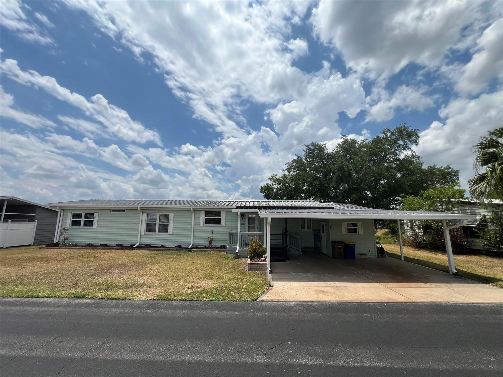 This MOVE-IN READY waterfront 2 Bedroom, 2 Bathroom manufactured home in the 55+ Floral Lakes Community in Bartow, FL is situated on Boca Cove and features double paned windows and sliding doors; newer A/C unit; metal roof; a spacious Kitchen with breakfast bar, island cooktop, built-in oven, dishwasher, and plenty of cabinets for pantry space; a separate Dining Area with built-in lighted China Hutch; and a large Living Room with sliding glass doors that open to the enclosed Florida Room.
In this split bedroom plan, the Primary Bedroom features a sliding glass door to the Florida Room, while its en-suite bathroom features a fiberglass shower enclosure, double vanities, and double linen closets. The Second Bedroom has an oversized walk-in closet and access to the Guest Bathroom. The Guest Bathroom features a large vanity and shower/tub combo. The laundry area, just off the Kitchen, includes a laundry tub and washer and dryer.
The double carport includes a wheelchair lift, designed to provide easy access to the home's entrance for individuals using wheelchairs or scooters, and a workshop/storage room. There is an additional screened storage area in the rear of the home. Spacious wood dock for fishing Boca Cove, with room to bring your boat!
Located in central Florida, between Tampa and Orlando, this golf cart friendly community is near the Bartow Civic Center, Bartow Public Library, and Mary Holland Park. Here you OWN YOUR LAND (no lot rent) and pay low monthly HOA fees. The Floral Lakes community offers access to a stocked pond with community boat ramp and dock. Clubhouse amenities include recreation space, shuffleboard, putting green, and large heated swimming pool. Social clubs, dances, exercise, pot lucks, and MORE! Association approval is required for purchase. Call your Realtor today for more information and to schedule a showing!