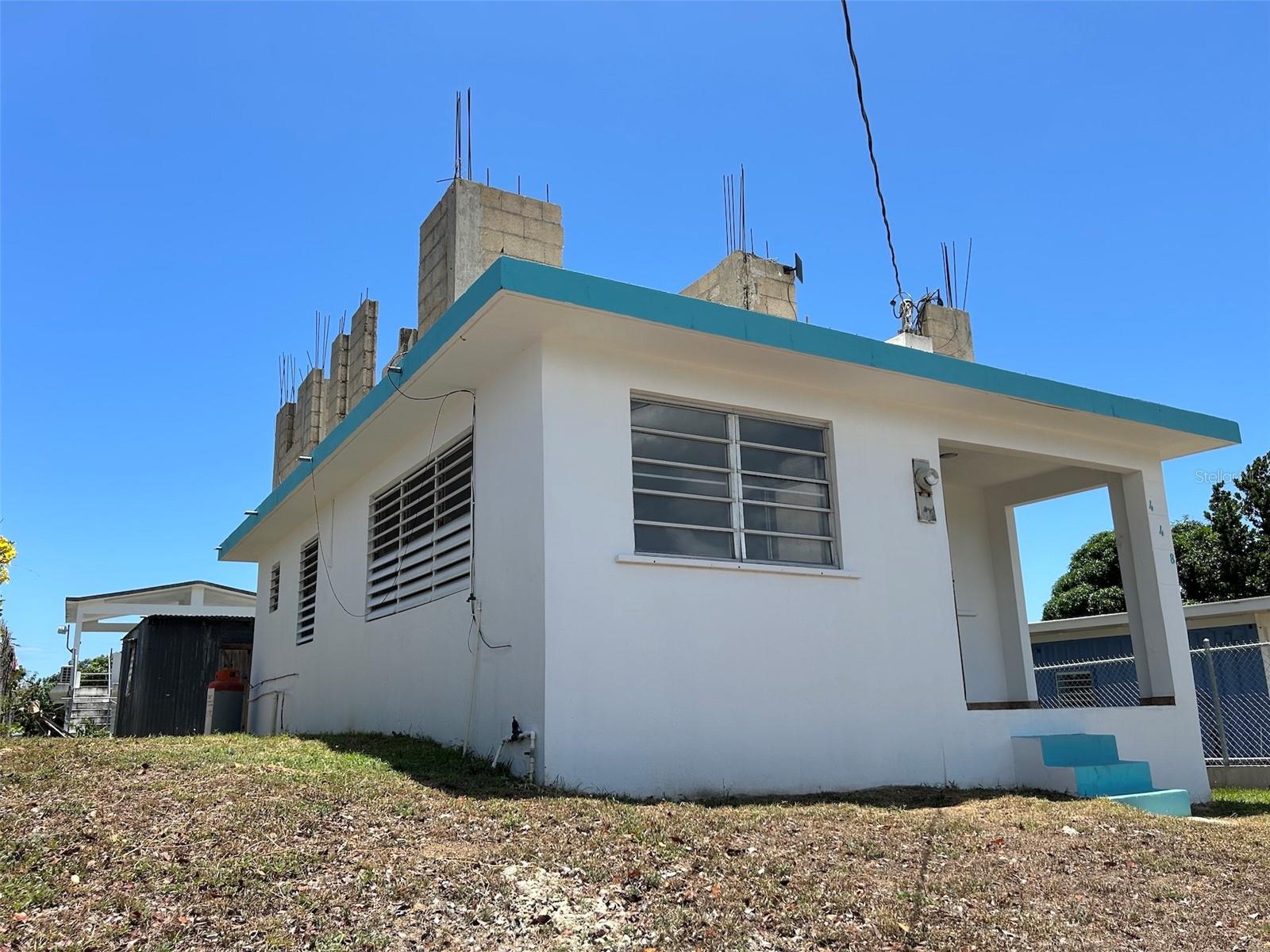 Perched on the higher edge of the neighborhood with ocean & country side views and a constant breeze…
This simple, well built residence is walking distance to several stunning beaches, the south shore restaurants & boutiques, grocery stores, The Vieques Trust, and the famous “Malecon”. Walk into your own tiny Caribbean getaway with two bedrooms, one bath, front balcony and the beginnings of a second story expansion. The medium sized yard (333 square meters), offers a great open space plus an outdoor tool shed. There are currently no properties for this price in Esperanza that require little to no work..!