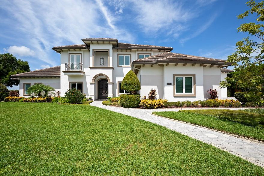 Discover the epitome of luxury living in this exquisite lakefront estate located in the exclusive Windermere community of Sawyer Cove. This high-end residence offers 4 spacious bedrooms, 5 luxurious bathrooms, and over 5,700 square feet of meticulously designed living space that effortlessly blends elegance with comfort. The heart of this home is the stunning gourmet kitchen, featuring a professional Thermador stove with a six-burner gas cooktop and built-in griddle, complemented by both a main oven and a half oven for maximum culinary versatility. Additional highlights include a warming drawer, a top-of-the-line Sub-Zero refrigerator and freezer (36”/18”), and a unique copper sink that adds a touch of luxury to everyday tasks. Retreat to the first-floor luxurious primary suite that opens directly to the pool area. With plantation shutters, dual sinks, a separate shower, and a jacuzzi tub, the spa-like ensuite also features a walk-through closet, a linen closet, and an indulgent “spa shower” equipped with dual shower heads and body spray for a truly rejuvenating experience. All other bedrooms have ample space, complete with walk-in closets and ensuite bathrooms for maximum privacy and comfort. Elevate your entertaining with a fabulous wet bar and bonus room on the second floor, featuring a dumbwaiter for seamless service. The bar includes an ice maker, dishwasher, hidden TV, wine refrigerator, microwave, and beverage refrigerator, making it the perfect spot for gatherings and celebrations. Step outside to your private paradise, featuring a state-of-the-art outdoor kitchen complete with a grill, propane burner, and plenty of seating for entertaining. Cozy up by the fireplace or gather around the firepit for evenings under the stars or while watching the nightly Disney fireworks over the lake. The patio is furnished for relaxation, and the boat dock invites you to set sail on the water, while a pool bathroom adds convenience for your guests. This home is equipped with a generator for added peace of mind, whole house water softener, Reverse osmosis system in both the kitchen and wet bar, an expansive RV garage (22’ x 50’) with a separate climate-controlled unit, an indoor climate controlled workshop with its own entrance, large laundry room, home office, an intercom system, extensive storage options, and surround sound throughout the home. Elegant crown molding and mature landscaping enhance the property's aesthetic, providing a tranquil and inviting atmosphere. Included in the sale are all TVs and furniture, ensuring a seamless transition into your new luxurious lifestyle. This extraordinary lakefront home is a true sanctuary of elegance and sophistication, providing everything you need to enjoy the serene lifestyle of Windermere. Don’t miss your chance to make this dream home yours!