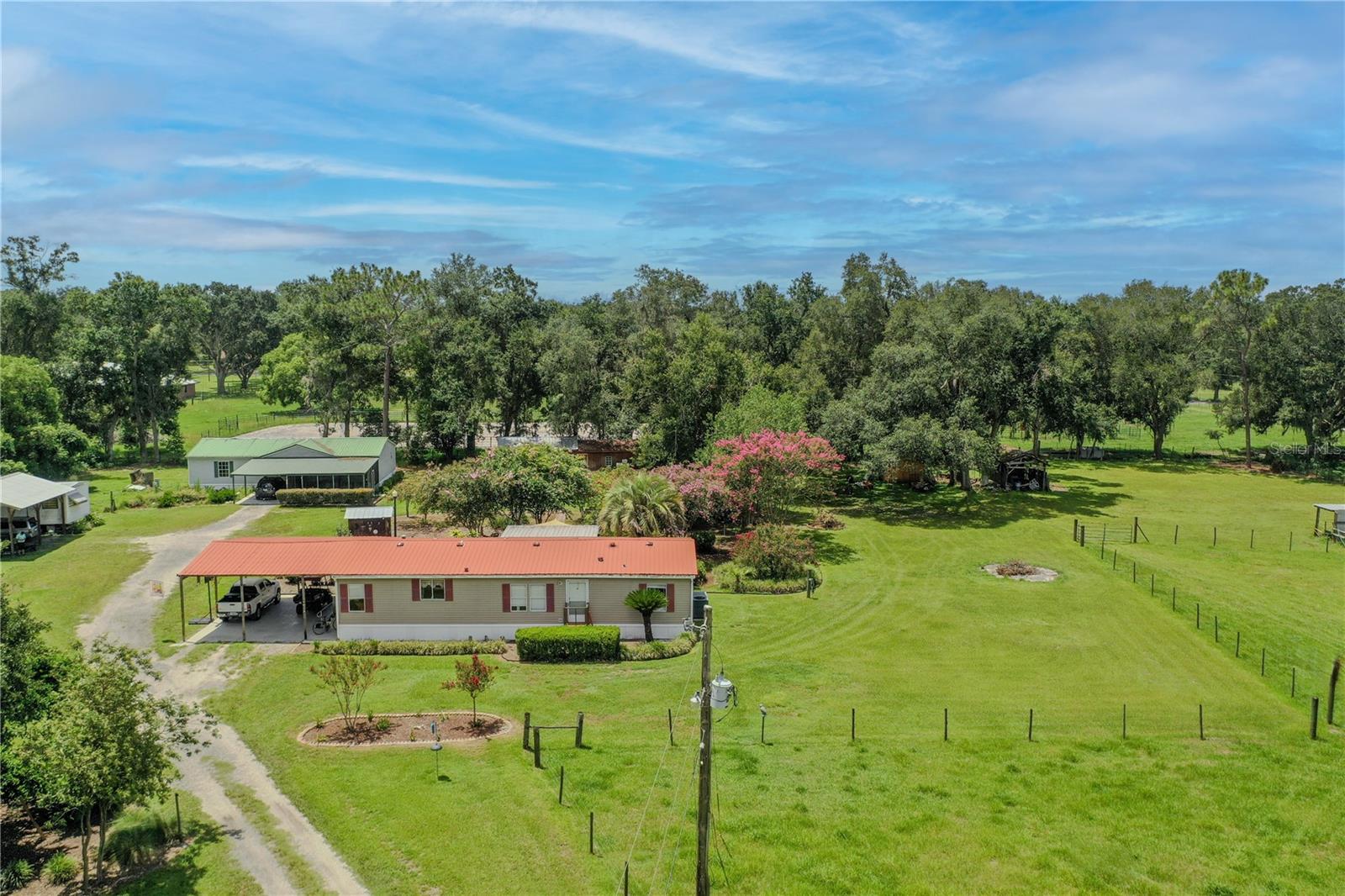 Nestled on a sprawling 8.2-acre private wooded property, this unique listing features TWO double-wide mobile homes, each boasting three spacious bedrooms and two bathrooms with open floor plans designed for comfort and convenience. Each having it's own unique address. Imagine starting your day on the charming screen porches, where you can sip your morning coffee while soaking in the serene natural surroundings. Whether you’re looking for a family compound, potential rental income, or a cozy mother-in-law suite, this property offers endless possibilities to suit your lifestyle. The property comes complete with a workshop and ample storage, perfect for hobbyists, DIY enthusiasts, or anyone in need of extra space. Cross fenced, with plenty of room for horses, cows, and other livestock, you can embrace a rural lifestyle while still enjoying proximity to urban amenities. Conveniently located with easy access to Interstate 4, you’ll find yourself centrally positioned between the vibrant cities of Orlando and Tampa. This prime location provides the perfect balance of tranquility and accessibility. Completing this exceptional offering is the beautiful mature landscaping, creating a picturesque backdrop for your new home. This is a must-see property that harmonizes nature and comfort, making it an ideal investment for both personal enjoyment and potential income. Don’t miss this rare opportunity! Schedule your private tour today and step into the lifestyle you’ve always dreamed of!