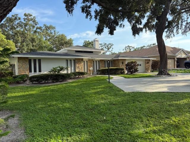 Wonderful spacious house on .68 AC of land! 3 bedrooms 3 bathrooms plus a den that could be a 4th small bedroom. The large family room/ great room has a soaring ceiling and skylights and features a large stone fireplace. Separate dining room. The big kitchen opens to the Family Room and also has a pass-through counter to the summer kitchen. There are sliding door entrances to the pool are from the family room, master bedroom a second bedroom. There is a loverly large swimming pool with a waterfall contained in gaged area which includes a large eating area under cover. Because of the generous sized lot there is ample fenced in land behind the pool area. The house is located in an excellent area of Clearwater and close to direct transport to Clearwater Beach, Tampa International Airport and downtown St Petersburg.