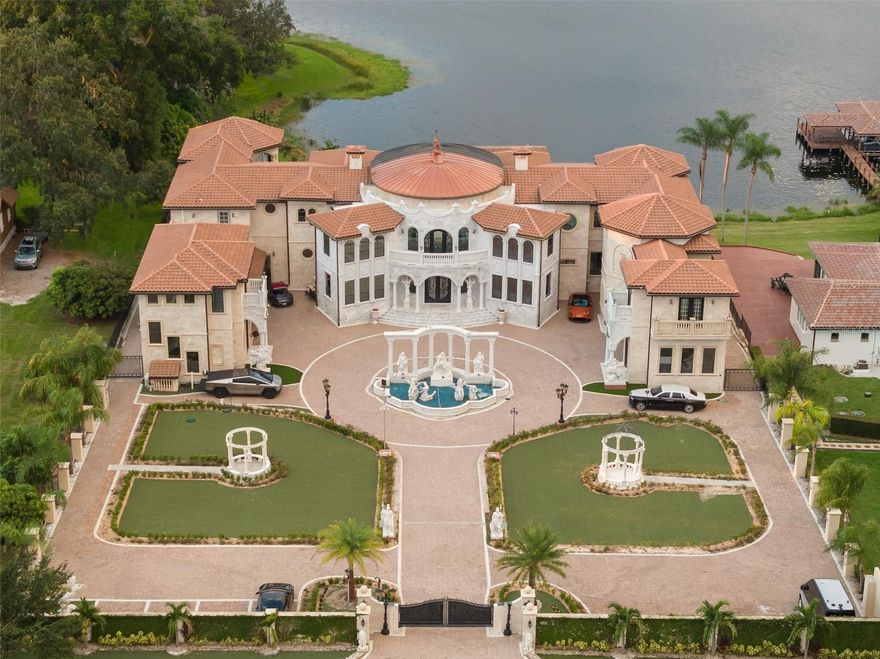 Welcome to a residence that transcends even the highest expectations of luxury living! This is a once-in-a-lifetime estate where architecture, scale, and location combine to create an experience that is as rare as it is breathtaking.
From the moment you arrive, the home commands attention with a grand, Mediterranean-inspired façade that opens to interiors of soaring scale and meticulous marble craftsmanship. Light cascades through walls of glass, illuminating a series of living spaces designed for entertaining at the highest level.
Every detail speaks of refinement: bespoke millwork, hand-selected stone, intricate ceiling treatments, and custom finishes curated with an uncompromising standard. The expansive chef’s kitchen blends culinary excellence with artful design, while the bar, wine room, and multiple gathering spaces ensure that every occasion, from intimate family dinners to grand celebrations, is unforgettable. The state-of-the-art theater begs you to slow down and enjoy the latest movie release.  Conveniently adjacent to the theater is a home gym and lakefront cardio room that rivals most commercial gyms! Once the day winds down, the private retreats within the home offers warmth and convenience so you never have to leave. The first floor conveniently offers a full guest suite, and the second floor boasts an additional four bedrooms all with en-suite bathrooms.  Additionally located on the second floor is a kid’s study, playroom, guest apartment and handsome cigar room.  
Outdoors, the estate transforms into a private resort. A sweeping terrace frames an oversized resort style pool and spa, surrounded by gardens, fountains, and tranquil seating venues. Enjoy the piece of your surroundings, from al fresco dining beneath the pergola to evenings spent overlooking Lake Olivia, one of Central Florida’s most sought-after ski lakes. 
Beyond the main residence, a detached guest retreat and showcase garages offering space for up to 14 cars will satisfy the most serious car collector. Set on a significant 4.43 acre parcel of land, the estate is both sanctuary and statement, offering numerous spaces to live, create, and entertain.
Enjoy living in the heart of it all without compromising your privacy. Plus, with easy access to major highways, theme parks, downtown Windermere, and less than 10 minutes from Whole Foods, Restaurant Row, and championship golf courses, you’re never far from the very best of what Central Florida has to offer.  Perfectly positioned with easy access to Windermere Prep, Lake Highland, and Montverde Academy...this location does not get any better!
Rarely does a property of this magnitude become available. This is not simply a home — it is an heirloom, a landmark, and an invitation to experience luxury on a level few will ever know. Call today for an exclusive private showing.