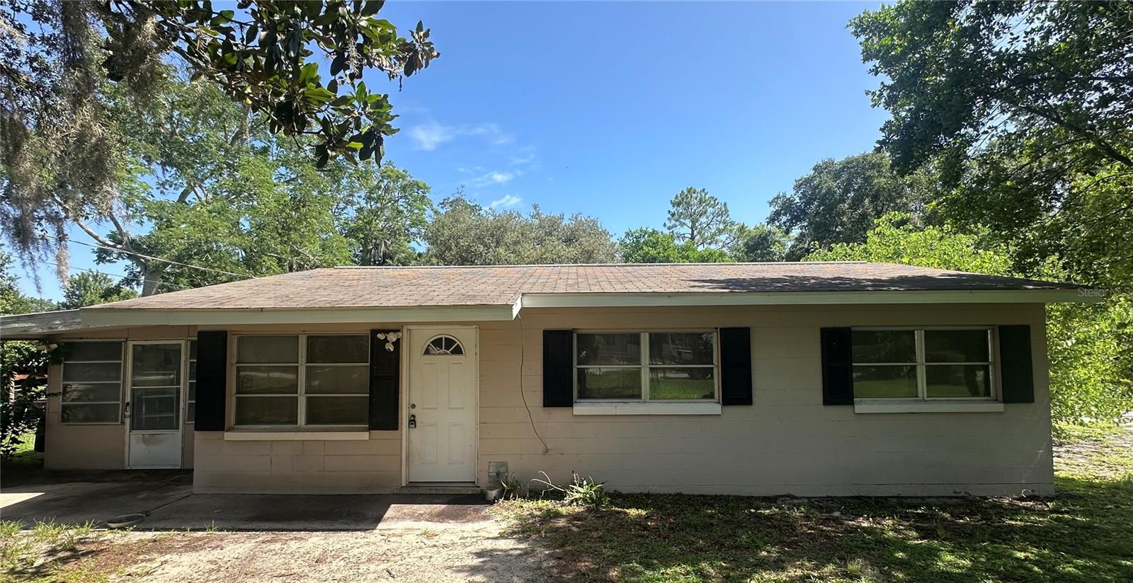 Nice starter home. You may qualify for a $0 down payment. This 2-bedroom, 1-bath block home features an updated HVAC system from 2022, a well pump Motor Replacement in 2025, 3 wells, Terrazzo floors, a New roof, and an electric panel that will be updated before closing. This home is on a large lot with beautiful trees, just over 1/2 an Acre, chain link fenced. Before the expansion of the living room, a wall divided the living room and the 3rd bedroom.