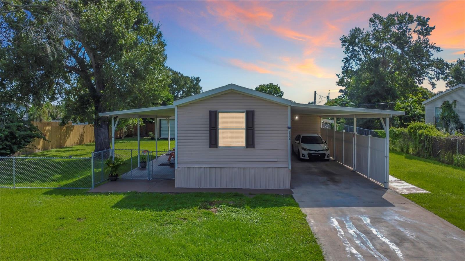 NO HOA—bring your boat, work truck, or toys! Tucked in the established Country Green area, this move-in ready 2005 manufactured home sits on a quarter-acre (approx. 85’ x 132’) lot with a HUGE 648-sf covered carport/lanai and long driveway. Inside you’ll find easy, single-level living with tile floors throughout, an open living/dining area, a roomy kitchen, indoor laundry, and a spacious primary suite with sitting area and en-suite bath. Outside, enjoy the fully fenced yard, shade trees, front and side covered porches, and a storage/utility area—perfect for pets, play, and weekend projects. Fantastic location close to restaurants, supermarkets, Downtown Kissimmee, and Kissimmee Gateway Airport with quick access to US-192, John Young Pkwy, and the Turnpike. Public records indicate 3 beds/2 baths and ~924 sf; buyer to verify all measurements and room count. Flood Zone X per FEMA (generally outside special flood hazard areas). Come see it today!