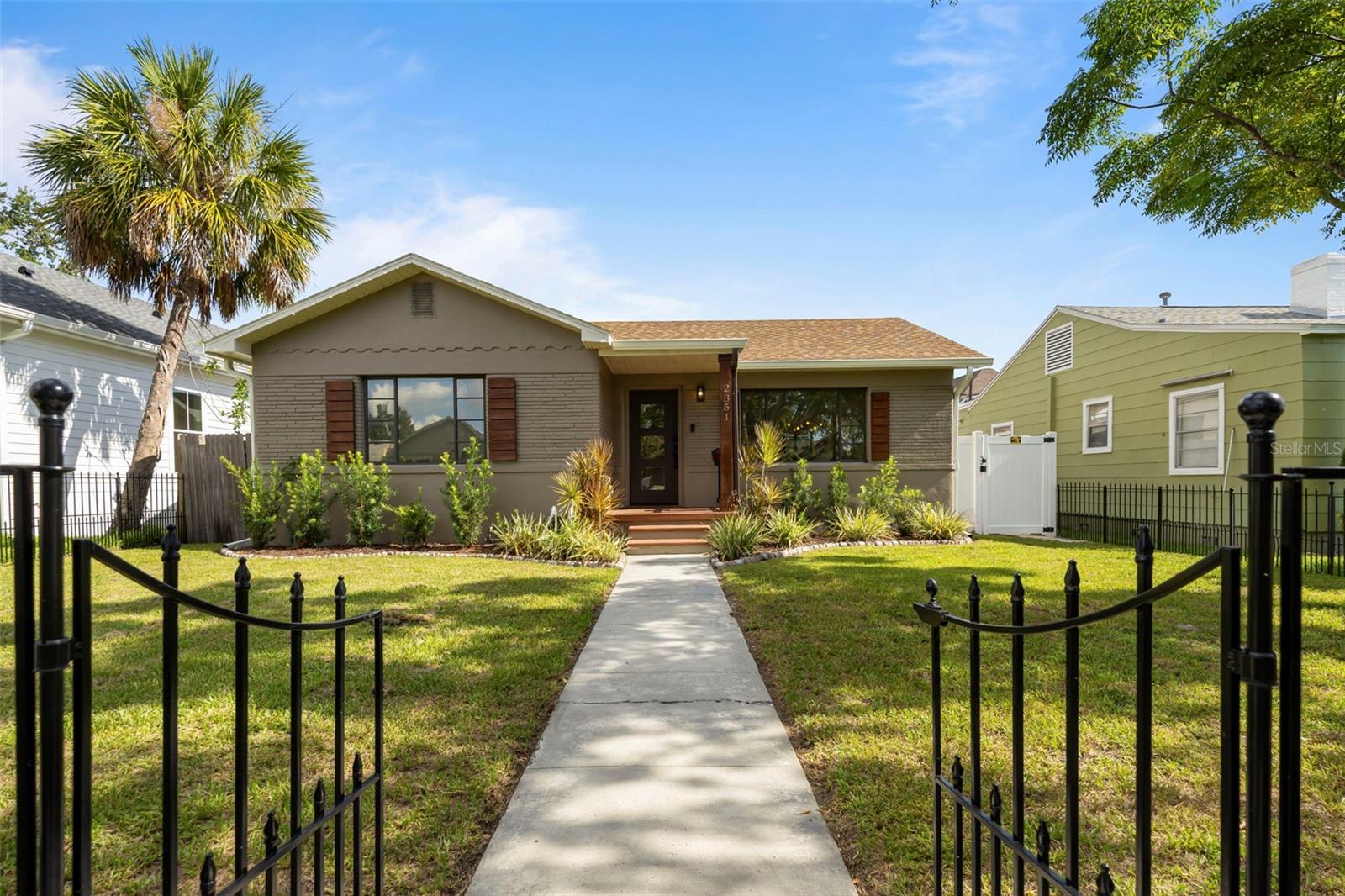 Welcome to 2351 4th Ave S, a beautifully updated mid-century home located in the desirable Palmetto Park neighborhood. Located High & Dry in Flood Zone X (No Flood Insurance Required, and No Flooding From the Storms!) and within Steps to Central Ave, the Urban Warehouse Arts District, Local Breweries, and Booming Downtown St Petersburg. Set on a picturesque brick-lined street (With Sidewalks) surrounded by a mix of historic homes and modern builds, this home has undeniable curb appeal with its fully fenced and gated front entry and inviting front porch. Inside, you’re welcomed by a spacious family room that flows seamlessly into the dining area and kitchen, connected by a stunning original arched opening that adds character and warmth. All of the floors are new, stunning, wide, luxury planked vinyl. The kitchen is thoughtfully designed with 42" cabinets with crown molding, quartz countertops, stainless steel appliances, open shelving, and tile backsplash. Through the kitchen you will find a mudroom with access to the one-car garage as well as the wooden deck; Perfect for grilling or entertaining. Just off the mudroom is the private primary suite, tucked away from the rest of the home, creating a split floor plan. The primary bedroom features a beautifully updated en-suite bathroom with new floors, and a relaxing tub. ALL bedrooms have new, custom closet systems, offering exceptional organization and storage. On the opposite side of the home, off the main living space, are two additional generously sized bedrooms, a full bathroom that has been completely and tastefully renovated, and a convenient laundry closet with a new washer and dryer and even extra room for storage- unheard of in St. Pete. Every detail in this home has been considered for functionality and style. Step outside to a large backyard, complete with a full covered carport (You can use for parking or entertaining!) with alley access, a new vinyl PVC fence with a rear gate (The west side of the gate being replaced at the sellers expense in September), and ample space for entertaining, gardening, or even adding a pool. Trash pickup from the alley adds a layer of convenience to your daily routine. This home offers 3 bedrooms, 2 bathrooms, and over 1,400 square feet of living space on a sizable 6,382 square foot lot. Built in 1953, it has been thoughtfully updated while maintaining its original charm, with the roof replaced in 2016 and HVAC in 2023! Enjoy the walkability to coffee shops, galleries, breweries, and local restaurants, all just blocks away. Don't miss your opportunity to live in one of St. Pete’s most sought-after neighborhoods in a move-in-ready home, with the perfect mix of old Florida charm and modern upgrades.