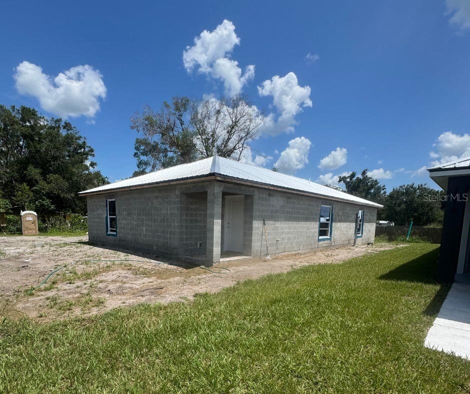 Under Construction. This Jewel Contracting new model 3 bedroom, 2 bathroom concrete block home with a metal roof will be ready by fall 2025! This home will boasts an open floor plan and a split bedroom design. You'll fall in love with the modern look of this home with its cathedral ceilings, HUGE center island, stainless steel appliance package and luxury vinyl plank flooring throughout. The home also offers plenty of storage with a large kitchen pantry, multiple soft close drawers and cabinets, and a generously sized dedicated laundry room. The bedrooms are each equipped with their own spacious closets and the primary bedroom supports an ensuite bath with a gorgeous walk-in shower. This location is close to parks, shopping, dining and conveniences. Unlike the other models on this street this come offers a larger lot and more square footage and is the only one of its kind! PSA- homeowner fee is a small fee for maintenance of shell, gravel and dirt roads in the area and water/ sewer services, there are no deed, historical or association restrictions on these homes it is simply a fee for maintenance to keep the neighborhood looking beautiful.