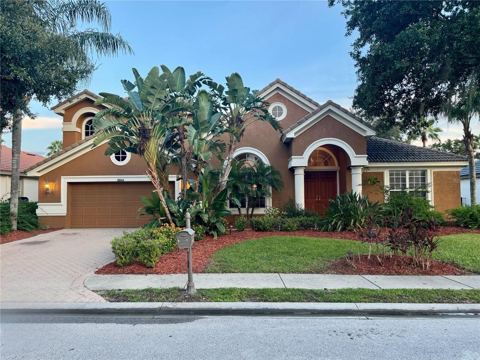 Welcome to 10644 Garda Drive, an elegant residence located in the highly desirable Cielo subdivision at Champions Club, one of Trinity’s premier gated communities. This beautifully designed two-story home offers 4 bedrooms, 4 bathrooms, and 3,828 square feet of elegant living space, thoughtfully crafted for comfort, function, and entertaining.
Step through the grand entryway and into an expansive open floor plan highlighted by soaring ceilings, graceful archways, and abundant natural light. The main living area includes a warm and inviting wood-burning fireplace, ideal for cozy evenings or gathering with friends. The chef’s kitchen features cherry wood cabinetry, granite countertops, and ample workspace—perfect for everything from everyday meals to holiday hosting. The layout is made for entertaining, with formal and casual spaces that flow effortlessly throughout.
The first-floor primary suite is a private retreat with direct access to the pool, a luxurious en-suite bath with jacuzzi tub, dual vanities, and a large walk-in shower. One of two additional downstairs bedrooms also opens directly to the pool through the bathroom, ideal for guests or multi-generational living. A separate home office with hardwood floors offers the perfect space for remote work or study.
Upstairs, enjoy movie nights in your very own home theater, which includes upgraded plumbing for a future bar, plus a spacious recreation room perfect for gaming, hobbies, or a secondary living area.
Step outside to your screened-in pool and spa, ideal for relaxing or entertaining year-round. The outdoor space also features a brick patio for lounging or dining al fresco in the Florida sunshine. While the pool area is private and peaceful, the front of the home offers rolling views of the 14th hole at the renowned Fox Hollow Golf Club, providing a scenic and prestigious setting. Additional highlights include a separate indoor laundry room, a two-car garage, and black metal fencing enclosing the backyard for security and peace of mind for young kids or pets.
Living in Champions Club means access to an exceptional lifestyle. This luxury golf course community features a private residents' clubhouse, resort-style heated pool, fitness center, tennis and pickleball courts, basketball, and year-round social events and activities for all ages. Enjoy the convenience of being just minutes from top-rated schools—Trinity Elementary, Seven Springs Middle, and J.W. Mitchell High—as well as medical facilities, local restaurants, shops, Starkey Market, scenic trails, and the beautiful Gulf Coast beaches. Commuting is a breeze with easy access to Tampa, Tampa International Airport, and St. Pete–Clearwater Airport.
Don’t miss this rare opportunity to own a one-of-a-kind home in a truly resort-style community. Come live the Florida lifestyle you've been dreaming of at Champions Club.