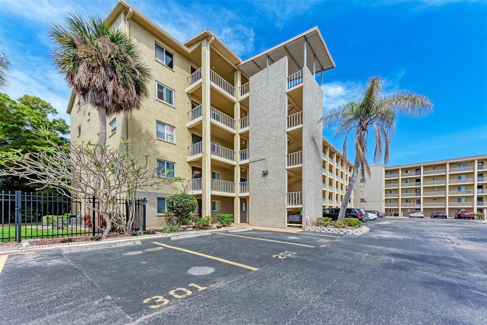 Discover the perfect blend of privacy, location, and potential in this 2-bedroom, 2-bath first-floor end unit tucked away at the very back of the community—no neighbors behind you, just peaceful views and a quiet setting. This unit also comes with a designated parking space not far from your front door. Just outside the back door is a beautiful green space with a picnic table that nobody seems to know about so it would be a great spot to have coffee or read a book. Ready for your personal updates, this home offers an unbeatable foundation in one of the area’s most welcoming neighborhoods, complete with sparkling pools, tranquil lakes, fishing, and a lively clubhouse for socializing and events. There are so many restaurants and stores nearby making this an ideal location for your Golden Years!
Only 7 miles from our award-winning Gulf beaches, you’ll be living just minutes from sand, sun, and stunning sunsets. For peace of mind, the building was tented in August 2023, and the newly required Florida engineer assessment has been completed. Move in, make it your own, and start enjoying the Florida lifestyle you’ve been dreaming of!