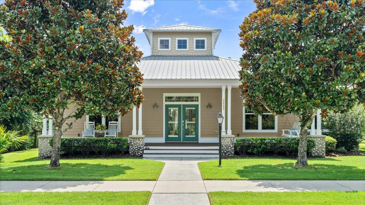 Timeless Florida Charm Meets Modern Elegance in the Florida Days gated community! Step into a world of warmth, style, and serene natural beauty in this stunning Hickson-built home, located on a corner lot and nestled beneath a canopy of mature oak. Designed in true Old Florida architectural style, this home invites you to soak in every carefully crafted detail—from its metal roof, oyster shell stucco and wide open porches to the shiplap siding. One of the most distinctive features of this property is its signature cupola—the only one of its kind in the neighborhood—flooding the home with natural light. The main living area has soaring ceilings, anchored by a distressed reclaimed wood beam with nautical-style rope accents, and a ceiling fan perched at its end. The kitchen has been thoughtfully designed for both beauty and functionality. Crisp white cabinetry is paired with sleek granite countertops, a white tile backsplash, and a stainless-steel appliances. A built-in wine rack, glass-front display cabinet, and large walk-in pantry elevate the space for entertaining or everyday ease. The split-bedroom floor plan ensures privacy and comfort. The spacious primary suite has amazing features such as coffered tray ceiling, ceiling fan, and large walk-in closet perfect for a Florida-inspired wardrobe. The primary bath has a double-sink vanity and a beautifully tiled walk-in shower. Two guest bedrooms are thoughtfully positioned around a shared bathroom. The front guest bedroom, with double French doors opening to the living room, offers flexible use as a home office, den, or additional guest space. The interior laundry room makes laundry day a breeze and provides additional storage. Crown molding, wood-like tile flooring, recessed lighting, chair rail accents are just some of the added features in this well-appointed home. Outdoor living is just as enchanting. The welcoming front porch is ideal for relaxing with a swing or rocking chairs, while the rear deck, accessible through sliding glass doors off the living room, is perfect for cookouts and casual entertaining. There’s even a firepit for gathering around on cool evenings. Practical features include a rear-loading separate 2 door garage accessible via a back alley, allowing for clean curb appeal and easy access to the home. Florida Days offers over 35 acres of private nature trails that weave through preserved land along the Spruce Creek corridor. The community features stocked fishing ponds, abundant wildlife, and is adjacent to the Doris Leeper Spruce Creek Preserve, offering more than 1,600 acres of hiking, biking, and kayaking opportunities. All of this just minutes from the charm of New Smyrna Beach, where you’ll find beaches, boutiques, restaurants, and a thriving arts scene.