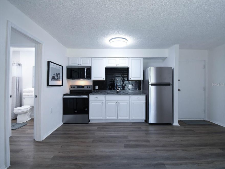 Completely renovated BOTTOM FLOOR and is move-in ready. Updates include a fully renovated open kitchen (2025), a completely remodeled bath with large-format tile (2025), a new air-conditioning unit (2025) and a new electrical panel (2025). The interior has been freshly painted throughout and features new luxury vinyl flooring, new kitchen cabinets, a new sink, a new range, a new microwave, a new refrigerator and a newly installed Ring camera doorbell. Enjoy the Florida lifestyle on your private screened lanai with an extra storage closet. Woodside Village is a desirable community offering resort-style living with three heated pools, a clubhouse, sauna, car wash station, barbecue area, shuffleboard court, lake access and three laundry facilities with new machines. Ideally just six miles from the beach, 10 minutes to Clearwater/St. Petersburg Airport, and close to shopping and dining. This all-ages community allows rentals after one year of ownership with a 30-day minimum lease. This condominium is an incredible opportunity you won’t want to miss!