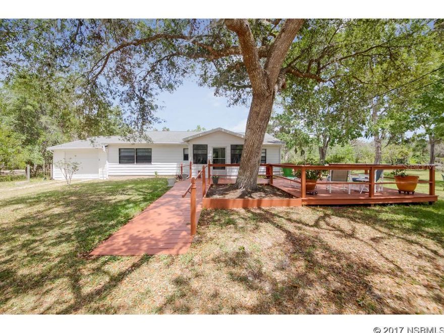 Tranquil setting on 2.60 acres in New Smyrna Beach.  This property is just waiting for the person that wants to be away from it all however close to everything.  Offering three bedrooms with one and a half baths.  Kitchen offers, breakfast nook, tile flooring and large pantry.  Formal dining area with fireplace.  Open living room area with large window.  Single car garage with workshop.  Huge deck off the kitchen, laundry area to enjoy the peaceful setting.