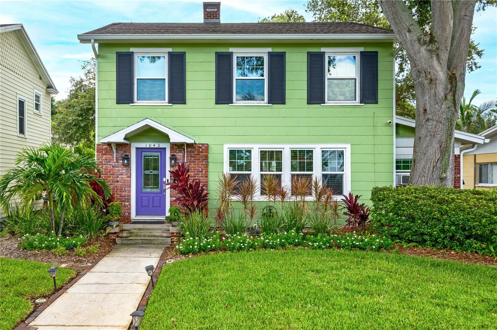 Welcome to the highly sought-after neighborhood of Euclid/St. Paul and this beautiful and fully-renovated Colonial-style home. This residence has been incredibly updated with virtually every modern convenience, while staying true to its original 1928 charm. Situated on the tree-shaded brick streets of this ever-popular area so close to downtown, this home was updated in the last six years in so many ways. From first sight of the vibrant violet-hued entry door and the beautiful garden landscaping, to the carefully-laid Augusta brick patios and walkways throughout the backyard, this home offers light and bright spaces and so many upgrades to weather our storm seasons. Classic hardwood floors of oak and heart of pine run throughout the home. The two story residence features two bedrooms and two baths upstairs, a half-bath downstairs and a bonus room for use as an office or flex space and an additional bonus office area attached to the garage. The living room is expansive, with a restored fireplace which has been converted to natural gas. Just off this space is a sun-filled flexible bonus room, ideal for a home office, workout room or playroom. The kitchen and dining area are spacious and surrounded by windows overlooking the backyard and outdoor dining area. The recently renovated kitchen is stunning, featuring all wood cabinetry, marble countertops, Samsung induction stove, Miele dishwasher, and wine cooler. Two large bedrooms and two fully renovated bathrooms are just up the staircase. The primary en-suite bathroom features custom built-in cabinetry, marble counters and tile and seamless glass shower. The inside laundry with stackable washer/dryer is just off the kitchen and leads to the classic and beautifully pavered Augusta brick and turf backyard. This area is perfect for entertaining, with alcoves for grilling, outdoor dining, play spaces, firepit area and more and all surrounded by beautiful custom wood and vinyl fencing for ultimate privacy. A detached two-car garage is just off the back steps, and features an additional 221 square feet of air conditioned space, perfect for a home office, work out room or flex space. Upgrades include newer roofs with double hurricane clips (2020) natural gas tankless hot water heater (2021), almost all windows replaced in 2021 with hurricane impact windows, the (4) lower front windows replaced and offer hurricane protective curtains, impact doors (2021), newer electrical throughout home (2021) newer electric panel (2024), all plumbing updated (2021), newer 24KW Generac full house generator (2023), newer gutters, newly installed French drains in backyard, well irrigation, new landscaping and lighting, Augusta brick walkways and patios and so much more. Absolutely move-in ready to immediately ENJOY! This picturesque property is located within an easy stroll to beautiful Crescent Lake Park, and is a 5-minute drive or quick bike ride to downtown St. Petersburg’s many restaurants, museums, theaters, shopping and entertainment. No flood insurance required. This beauty won’t last! Schedule your showing today!