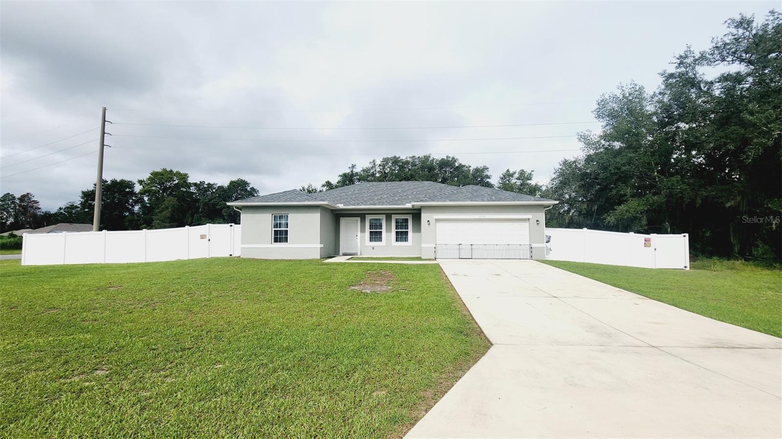 This stunning single-family home located on a huge corner lot measuring 15,682 sq. ft. was built in 2023, making it a brand-new construction that offers modern amenities and a fresh, contemporary design. This home offers open concept living with 4 spacious bedrooms 2 bathroom features ceramic tile flooring throughout, stainless-steel appliances including refrigerator, range, disposal, microwave, smart washer and dryer. Seamless gutters were installed in 2023. The kitchen has beautiful granite countertops, a sizeable island, wooden cabinets and sliding patio doors to the large, private backyard. The yard is enclosed with privacy fencing which includes 2 single 4ft gates and a double 8 ft gate. With its convenient, central location, the highway is 2.8 miles from home. Shopping, dining and top-rated schools for all ages are just as accessible.Whether you're looking for a peaceful retreat or a place to entertain friends and family, this home’s beautiful design and ample space both indoors and outdoors has everything you need to live your best life in Ocala, FL. Don't miss out on the opportunity to make this stunning property your own and start enjoying the Florida lifestyle today.
