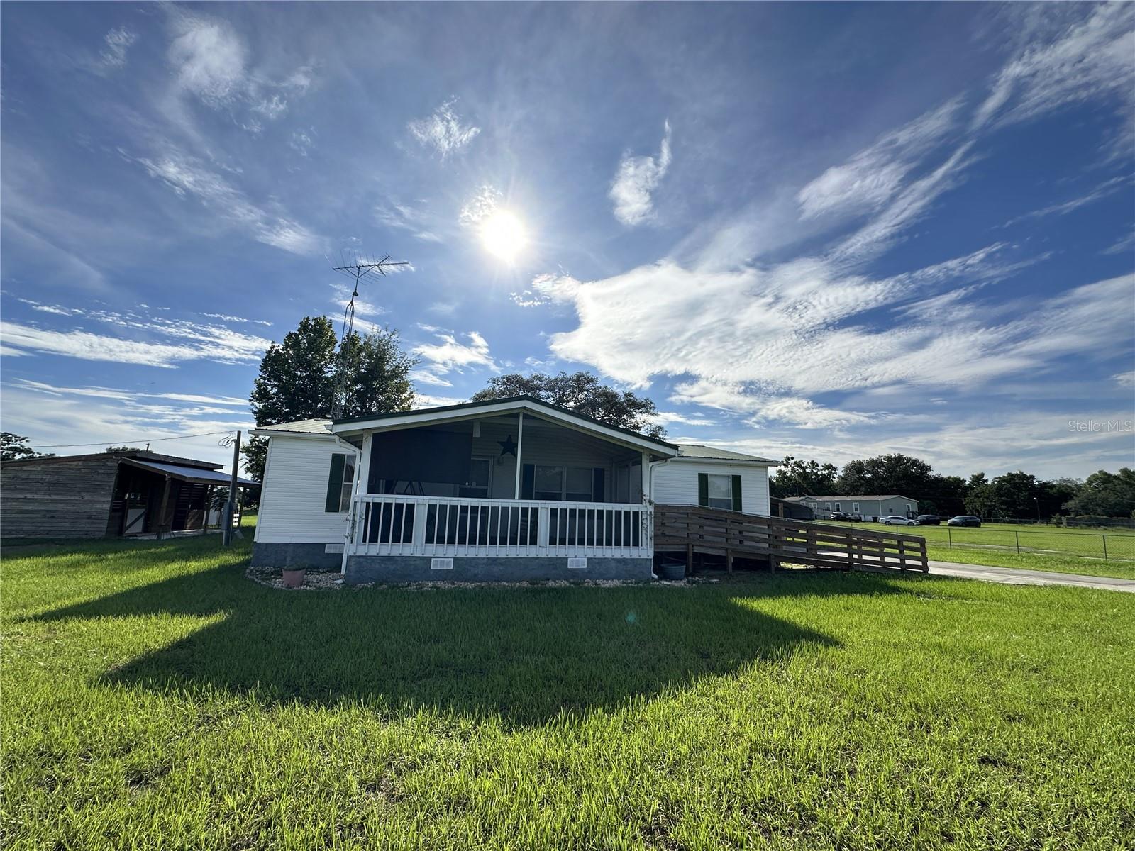Perfect place for your mini farm- rural living and comfort- 3.33-acre agricultural-zoned property in Belleview, Florida. Looking for country lifestyle? this property offers plenty of space for horses, farm animals such as donkeys, cows, lambs, sheep, chickens; gardens, or even a small hobby farm. The home offers a bright living space and spacious screen front porch, just what you need for relaxing evenings. Perfect to enjoy your morning coffee and watch the sunset, a total serene retreat. This property has a newer A/C and well pump and pipe, property is fully fenced, has a deck off the kitchen back door perfect for entertaining and grilling out. Aside from the deck is a concrete patio with a view of majestic oak tree perfect for climbing and provides great shade. Attached to the metal carport is a 16x32 shed with permits The property offers a barn for 2 horses, a workshop structures, and endless possibilities for animal lovers. Access to water for animals or gardening. As a bonus, the property is located near a lake, and for a small annual fee, you can enjoy access to a private boat ramp—ideal for boating, fishing, and weekend relaxation. Call Today for a private show.