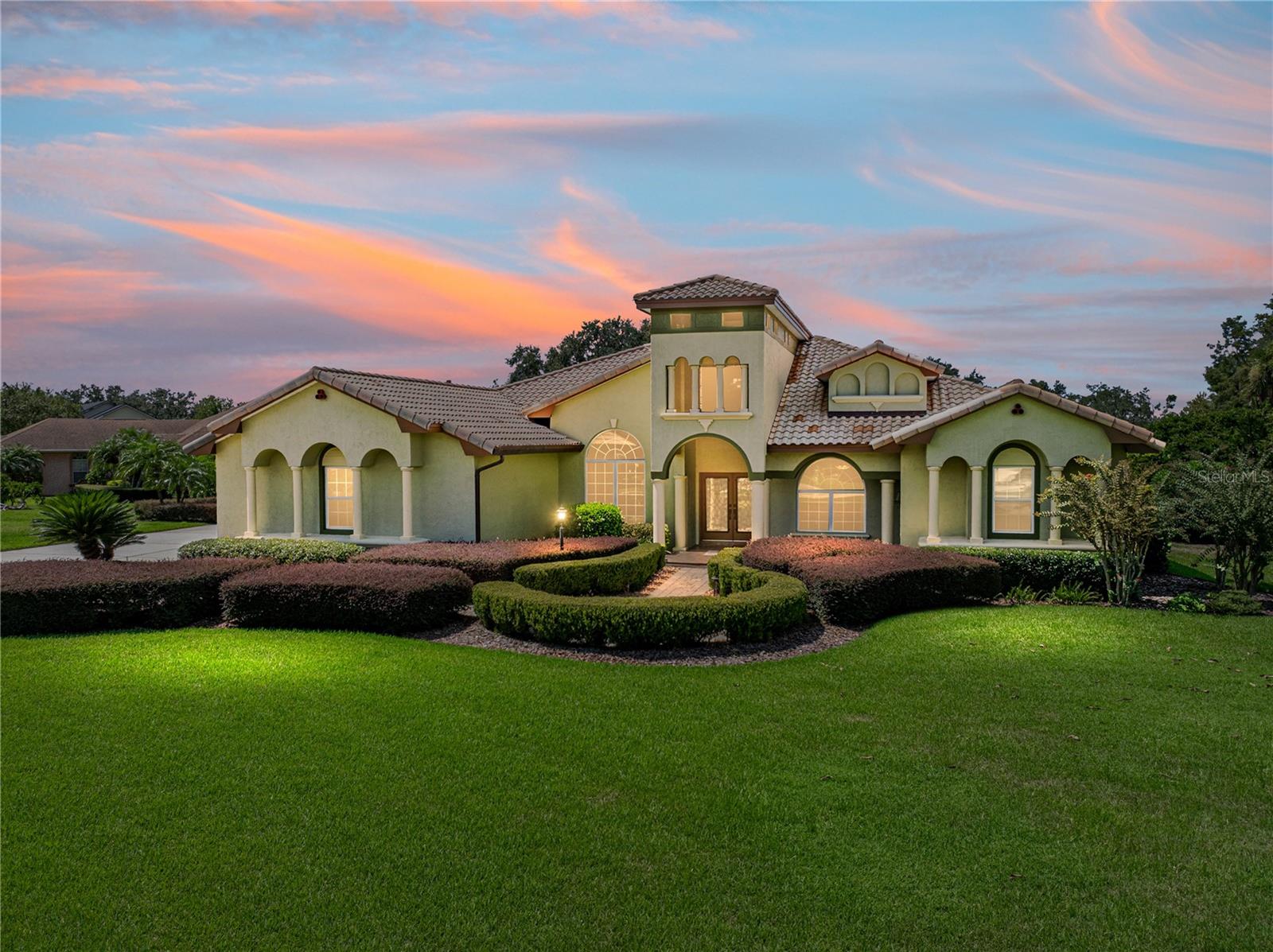 Offered for the first time, this stunning custom-built luxury home in SE Winter Haven in the gated community of Heron Cay. This exquisite Mediterranean style home features 3,640 square feet of living space with 4 bedrooms, plus a large flex room, 3 ½ baths plus a gorgeous pool and outside entertaining area on a lot measuring .61 acres. As you enter through the front double doors with custom decorative iron work and a soaring ceiling of over 21 feet, you are in a magnificent foyer. The living room has the first of two wood/gas fireplaces with views and access to your private pool via the oversized arched glass French doors on either side of the fireplace. The elegant dining room is oversized and perfect for large family gatherings or entertaining and is adjacent to your cook’s dream kitchen. In addition, off the entry foyer is a home office with a massive built in book case and desk with the flexibility to also be a 4th bedroom.
The kitchen is a culinary dream with custom cabinetry, granite countertops, a spacious island, a walk-in pantry and upscale stainless appliances including a gas stove and double wall oven. The kitchen overlooks the great room, the breakfast nook and the pool. The great room ceiling beams are another architectural feature, and a second wood/gas fireplace is a focal point of this amazing room. Crown molding, columns, hurricane rated windows, and a neutral color palette are throughout this home.
Next to the great room is a large bonus/ flex space with French doors that can be used as a playroom, a library or even a workout space.
The oversized primary bedroom has access out to the pool and features a spa type ensuite complete with a soaking tub and dual vanities. Twin oversized, walk-in closets feature built in shelves for keeping everything organized with access being via barn doors with glass panels.
The guest rooms on the other side of the house have separate toilet/vanity areas with a shared tub/shower and private hallway. These are the only two rooms with carpet and it is a low pile neutral Berber style. Both guest rooms have oversized, walk in closets and there is a large linen closet in the private hallway.
An indoor laundry room with built ins is well-located next to the kitchen and includes a laundry tub.
Outdoor entertaining is perfect for celebrations in the screened lanai with your heated pool and outdoor kitchen! It is also a tranquil space to enjoy your friends and family as the pool features both a fountain and an area for plants. A pool bathroom is off the covered lanai and features a shower making an after swim shower really convenient.
All of this beauty is set on professionally landscaped grounds with a whole house natural gas generator (2023) fed from the street and hurricane rated windows. The attached 3 car garage is oversized and features 3 separate garage doors and a driveway complete with a paver turnaround area for easy access in and out of the home. The home features a tile roof and many exterior trim details including landscape lighting only found in a custom, luxury home like this. The irrigation system is from this home’s private well.
Built by the original owners and meticulously maintained showing pride of ownership throughout. This home has a low HOA that includes cable tv and Wi-Fi and is convenient to shopping, doctors, hospitals and local state colleges. Centrally located for an easy commute to Orlando or Tampa. Enjoy the virtual tour via the link.