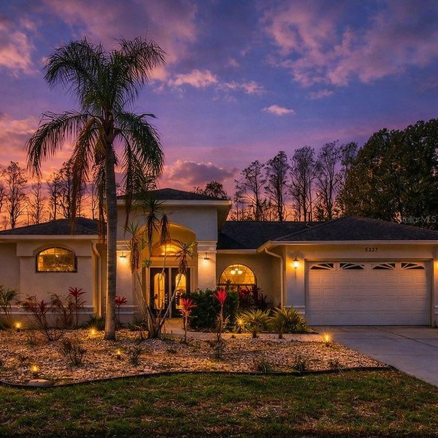 One or more photo(s) has been virtually staged. PRICED BELOW APPRAISED VALUE! Welcome to 5237 Las Flores Via, a private pool home with no front or rear neighbors, surrounded by nature preserves and no flood zone! A front pond with waterfall leads you into a bright, open interior with high ceilings, skylights and ceramic tile flooring. The kitchen features quartz counters, a convection oven with stovetop grill, abundant cabinetry, built-in desk and trash compactor. The primary suite offers dual walk-in closets, pool access, jetted tub, shower and double vanities. The opposite wing includes two large bedrooms and a full bath with double sinks. Enjoy Florida living with a screened pool and spa (new cage ~6 months old), outdoor kitchen, outdoor half bath, outdoor shower, covered lanai and fenced yard for your pups,  with your very own grapefruit, lemon and orange trees! Additional features: new gas fireplace, gas water heater, electric A/C, chlorine pool, 2-car garage. Roof 2015 · HVAC 2020 · Water Heater 2013. Convenient to schools, Hwy 54, Downtown New Port Richey, Trinity and Suncoast Pkwy. Schedule your tour today!