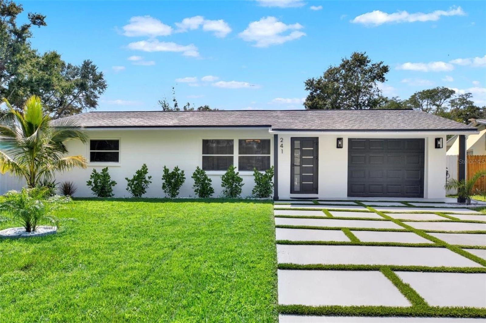 Welcome to your completely renovated 3-bedroom, 2-bathroom home with a 1-car garage, situated in a prime Largo neighborhood with NO HOA and located in a NON-FLOOD zone. This property has been meticulously upgraded with a focus on modern design and high-end finishes. The gourmet kitchen is a chef's dream, featuring European-style soft-close cabinets, Samsung Bespoke appliances, a stunning quartz waterfall countertop, and a stylish tile backsplash. Indulge in spa-like experiences in the luxurious bathrooms, boasting granite vanities, LED mirrors, custom tiled showers with frameless glass doors, and European-style dual flush toilets. Throughout the home, you'll find luxurious laminate flooring and smooth, modern walls, achieved by removing popcorn ceilings and professionally leveling and painting the surfaces. This home is smart home-ready, equipped with an EV charger in the garage, a Nest thermostat, and a fingerprint lock on the exterior side door for added security and convenience. Step outside to discover your outdoor oasis, transformed with new landscaping including palm trees, and a freshly painted exterior using Benjamin Moore paint. Enjoy the convenience of an extended driveway, artificial grass accents, and a new wooden fence for privacy. Experience peace of mind with a new roof flapper, updated electrical with GFCI outlets, new plumbing, and efficient LED lighting throughout. Perfectly positioned just a quick drive from beaches, parks, local shops, and dining, this home offers easy, low-maintenance Florida living in a great location. Words hardly express the extent of this home's transformation. To truly appreciate its beauty and comfort, a visit is essential! Don't miss the chance to own this exceptional property!