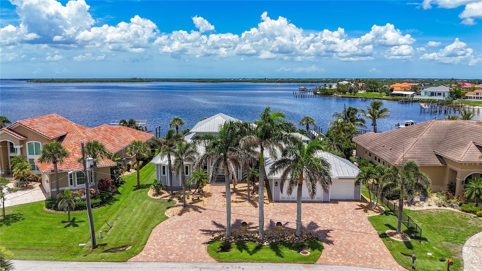 Stunning Charlotte Harbor Waterfront Home | Custom Tim Towles Build | 3BR + 2 Offices | 3,400 SF | 3-Car Garage
This exceptional 2-story custom home offers breathtaking unobstructed views of Charlotte Harbor from nearly every room. Privately nestled among million-dollar homes, this 3-bedroom, 2.5-bath estate includes two office spaces, a 3-car garage, and over 3,400 square feet of thoughtfully designed luxury. The grand living area impresses with 26-ft soaring ceilings, a 90-degree disappearing slider, and a striking aquarium window showcasing the water. The gourmet kitchen features solid wood cabinetry, granite countertops, a center island, and updated appliances, flowing seamlessly into the breakfast area and family room — all opening to the expansive saltwater pool and spa.
The private primary suite offers panoramic water views, direct lanai access, and a spa-style bath with dual-head walk-in shower, jetted whirlpool tub, and his & hers vanities. Upstairs, a loft with private balcony captures sweeping harbor views.
Two flexible offices add versatility — one with private entrance and harbor views, ideal as a media room, cabana, or bar. The second office, located off the kitchen, may also be used as a formal dining room. Key upgrades and features include: New dock (2025) with heavy-duty pilings, electric, two 7,500 lb boat lifts, new control boxes & remotes New shed (2023)Seawall and cap replaced (2017)Pool refinished and lanai floor redone (2018)Pool cage re-screened and re-screwed (2023) Saltwater pool system: filter/motor (2022), chlorine generator (2025 Whole-house water filtration system (2021) Generator panel with remote Two A/C units (2020 & 2023) Two water heaters (2022) — including one tankless All ceiling fans replaced (2024) All 7,000 roof screws replaced (11/2022) This move-in-ready residence combines custom craftsmanship, extensive upgrades,hurricane strenth windows and doors, and a premier location to deliver a true waterfront lifestyle with direct access to Charlotte Harbor and beyond. Sellers flood insurance is $1214.00 and transferrable Homeowner is $2755.00