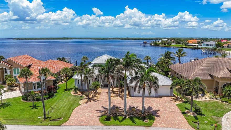 MAJOR PRICE REDUCTION!!! Stunning Charlotte Harbor Waterfront Home | Custom Tim Towles Build | 3BR + possible 2 Offices | 3,400 SF | 3-Car Garage.  This exceptional 2-story custom home offers breathtaking unobstructed views of Charlotte Harbor from nearly every room. Privately nestled among million-dollar homes, this 3-bedroom, 2.5-bath estate includes two office spaces, a 3-car garage, and over 3,400 square feet of thoughtfully designed luxury. The grand living area impresses with 26-ft soaring ceilings, a 90-degree disappearing slider, and a striking aquarium window showcasing the water. The gourmet kitchen features solid wood cabinetry, granite countertops, a center island, and updated appliances, flowing seamlessly into the breakfast area and family room — all opening to the expansive saltwater pool and spa.
The private primary suite offers panoramic water views, direct lanai access, and a spa-style bath with dual-head walk-in shower, jetted whirlpool tub, and his & hers vanities. Upstairs, a loft with private balcony captures sweeping harbor views.
Two flexible offices add versatility — one with private entrance and harbor views, ideal as a media room, cabana, or bar. The second office, located off the kitchen, may also be used as a formal dining room. Key upgrades and features include: New dock (2025) with heavy-duty pilings, electric, two 7,500 lb boat lifts, new control boxes & remotes New shed (2023)Seawall and cap replaced (2017)Pool refinished and lanai floor redone (2018)Pool cage re-screened and re-screwed (2023) Saltwater pool system: filter/motor (2022), chlorine generator (2025 Whole-house water filtration system (2021) Generator panel with remote Two A/C units (2020 & 2023) Two water heaters (2022) — including one tankless All ceiling fans replaced (2024) All 7,000 roof screws replaced (11/2022) This move-in-ready residence combines custom craftsmanship, extensive upgrades,hurricane strenth windows and doors, and a premier location to deliver a true waterfront lifestyle with direct access to Charlotte Harbor and beyond. Sellers flood insurance is $1214.00 and transferrable Homeowner is $2755.00