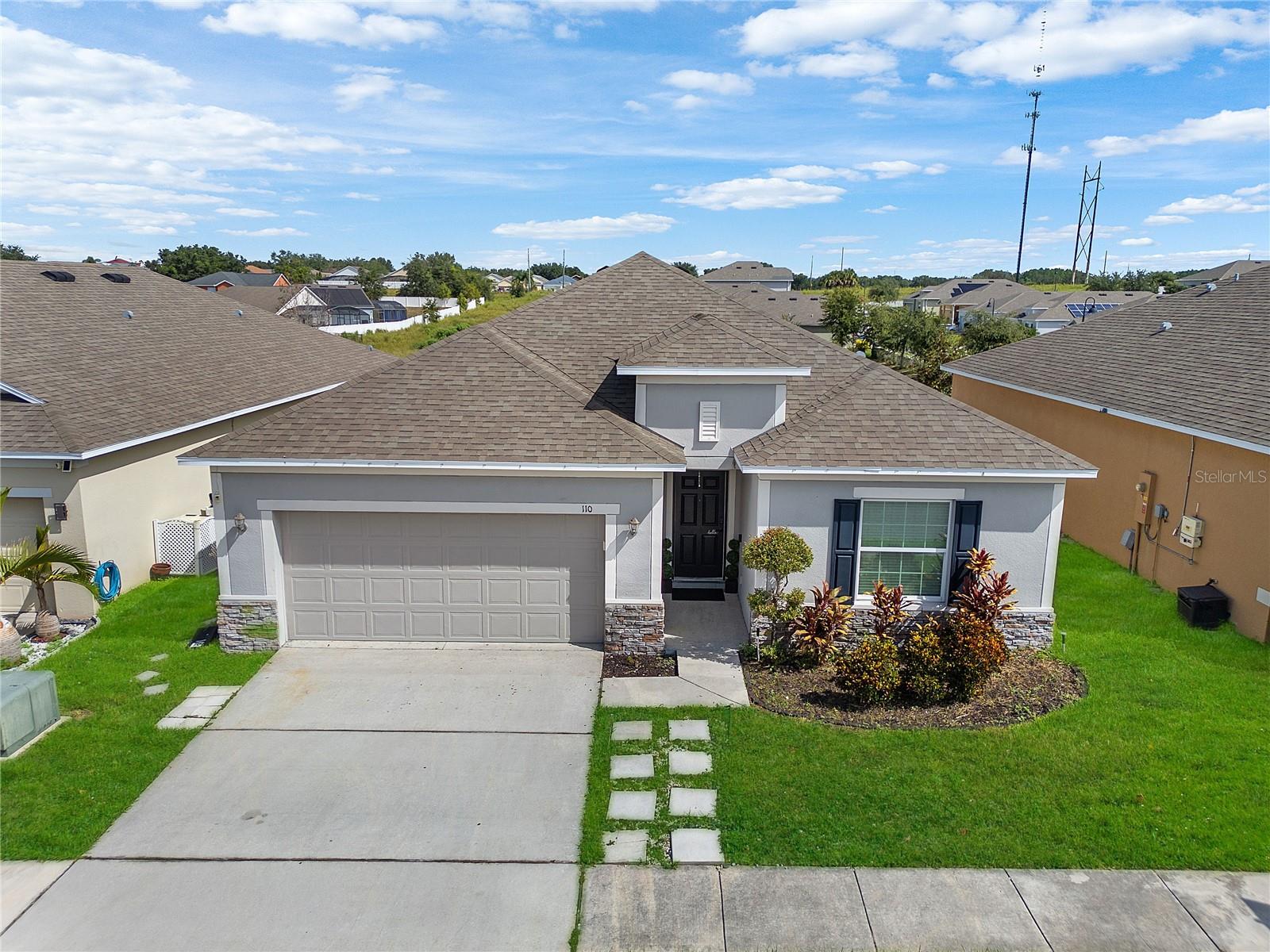 Step into modern comfort at 110 Flatwoods Loop in Davenport, FL! This stunning 4-bedroom, 2-bath home combines stylish upgrades with an open-concept layout designed for both entertaining and everyday living. At the heart of the home, the gourmet kitchen shines with sleek granite countertops, rich cabinetry, stainless steel appliances, and an oversized island that’s perfect for gathering with family and friends. The spacious living and dining areas flow seamlessly, creating the ideal setting for memorable nights in or relaxed weekends. Your private owner’s suite is a true escape, featuring tray ceilings and a spa-inspired bathroom with dual vanities, an oversized walk-in shower, and a luxurious soaking tub that invites you to unwind after a long day. Two additional bedrooms with flexibility for guests, or even a dedicated home office. Outside, enjoy curb appeal with modern stone accents, lush landscaping, and a two-car garage. Plus, you’re just minutes from Highway 27, I-4, and US-192, making it easy to access Orlando, Tampa, world-famous theme parks, shopping, dining, and entertainment. Whether you’re looking for your forever home or the perfect investment, this property offers the ultimate blend of style, comfort, and location in one irresistible package!