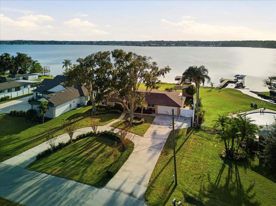 Tucked along the peaceful shores of Lake Gibson, this beautifully updated lakefront home invites you to slow down and enjoy the view. From the moment you arrive, it is clear this 3 bedroom, 2 bath home with a dedicated office has been lovingly maintained and thoughtfully improved, offering timeless charm, modern comfort, and the freedom of no HOA. Inside, natural light fills an open and welcoming floor plan designed for both everyday living and effortless entertaining. The great room and dining space come together around a cozy wood burning fireplace, framed by custom built ins, crown molding, and detailed craftsmanship that adds warmth and character throughout the home. Just beyond, the kitchen serves as the heart of the home with stainless steel appliances, granite countertops, rich wood cabinetry, and a cheerful breakfast nook overlooking the yard. A spacious interior laundry room with custom storage adds everyday convenience. The primary suite feels like a private retreat, where French doors open to a quiet patio and stunning lake views. The ensuite bath offers a relaxing garden tub, a separate walk in shower, and two generous closets, including a custom California Closet system. Two additional bedrooms, a full guest bath, and a versatile office provide plenty of space for family, guests, or working from home. One of the home’s most special spaces is the expansive, air conditioned/heated Florida Room, where walls of windows frame breathtaking lake views and create the perfect place to unwind or entertain year round. The possibilities are endless for this space from home gym, bar, homeschool room, game room your choice is yours. Outside, mature landscaping surrounds the property and is maintained with a lake fed irrigation system. A circular driveway, detached storage building with covered porch, and a private dock with covered boat slip complete the lakefront lifestyle. This home sits on over half an acre lot with plenty of room for an amazing lakefront backyard scape of your dreams. With major updates already completed, including a new roof in September 2024, double pane windows, recessed lighting, and updated plumbing and electrical systems, this move in ready home offers peace of mind along with beauty. Ideally located near shopping, dining, recreation, and easy access to I-4, this is lakefront living at its finest. Schedule your private showing and experience it for yourself.
