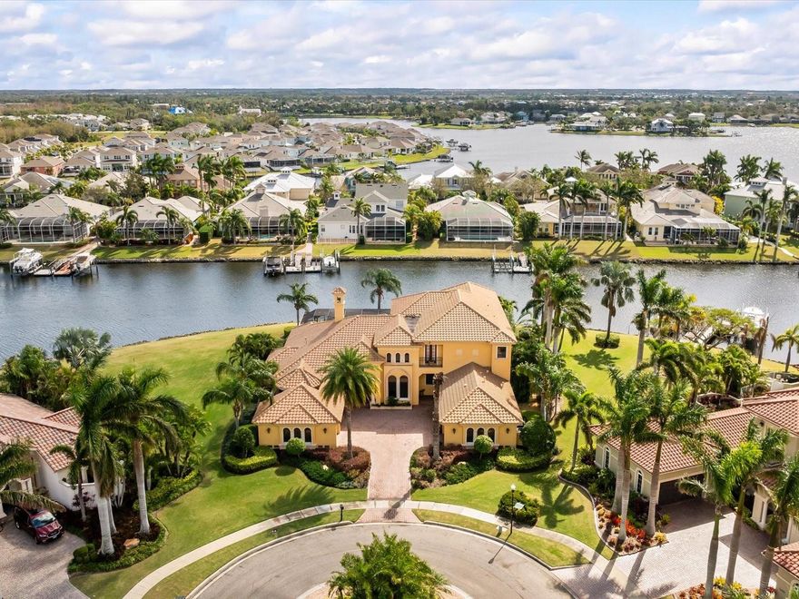 Extraordinary Waterfront Estate in the Bay Estates of MiraBay-

Designed for exceptional waterfront living, this custom John Cannon masterpiece is perfectly positioned at the end of a cul-de-sac in the exclusive, gated Bay Estates of MiraBay. Bathed in natural light and showcasing stunning water views throughout, this elegant estate blends timeless design with resort-style luxury—crafted for glamorous entertaining and effortless indoor-outdoor living.

A grand entrance through custom bronze doors welcomes you into a soaring foyer, setting the tone for the home's exquisite interior. Highlights include hand-scraped wide-plank hardwood floors, custom millwork, multi-tray ceilings, and a carved-stone fireplace. The spacious living room features built-in bookcases and expansive corner pocket sliding doors that reveal breathtaking views of the pool, spa, and waterfront.

The gourmet chef’s kitchen is a showstopper—featuring dual islands with granite countertops, custom soft-close cabinetry, a SubZero refrigerator/freezer, Wolf gas range and double ovens, onyx backsplash, two prep sinks, walk-in pantry, and a wine cooler. An adjoining breakfast room and sun-filled family room with more pocket sliders lead seamlessly to the screened lanai, outdoor fireplace, summer kitchen, and waterfront dining area.

The ultra-luxurious master suite is a private retreat with double tray ceilings, crown molding, a sitting room overlooking the pool, and a spa-worthy bath with granite countertops, custom cabinetry, a freestanding soaking tub, and intricate travertine flooring. Large windows frame a breathtaking hand-painted mural of the Amalfi Coast, adding a truly artistic touch.

Additional features include a 4-car garage and a heavy-duty boat lift—ideal for exploring the 135-acre lagoon and Tampa Bay's finest waterside restaurants and boating destinations.  Apollo Beach boasts some of the best year-round inshore fishing in Southwest Florida.

MiraBay residents enjoy access to resort amenities: a heated Olympic pool, waterslide, clubhouse, playgrounds, fitness center, and courts for tennis, pickleball, and basketball. Kayaks, paddleboards, and canoes are available to residents at no cost. Ideally located just minutes from I-75, top-rated charter schools, hospitals, shopping, Downtown Tampa, and the Gulf beaches—this is coastal luxury at its finest.

Your waterfront dream home awaits—schedule your private tour today.