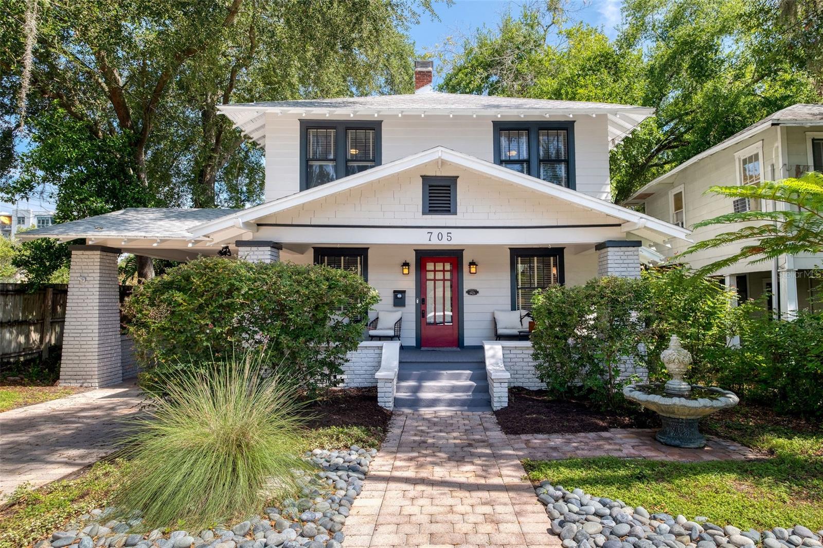 Classic Craftsman charm meets modern comfort in this beautifully updated 3-bedroom, 3-bath home in the heart of Thornton Park, just steps from all downtown Orlando has to offer. A welcoming front porch with a bold red door and views of majestic oak trees set the tone for the warm, inviting interiors. Inside, light-filled living spaces feature rich hardwood floors, crown molding, built-in storage, and a striking updated fireplace. The stylish kitchen blends timeless character with modern convenience, offering a farmhouse sink, granite counters, stainless steel appliances, and a brand-new tankless water heater. The spacious primary suite includes a spa shower, huge walk-in closet, and gorgeous downtown views. Additional highlights include cedar shelving, Kohler fixtures, abundant built-in storage, and a premium home warranty covering electrical, plumbing, and all major appliances. Recent upgrades include attic insulation, a 5-year termite bond, and a 12-foot security gate. French doors open to an inviting outdoor living space with a deck, pavers, yard, and a two-car garage complete with 220 fast-charging for electric vehicles. All this in a walkable, tree-lined neighborhood close to parks, restaurants, Lake Eola, and the vibrant Thornton Park lifestyle.
