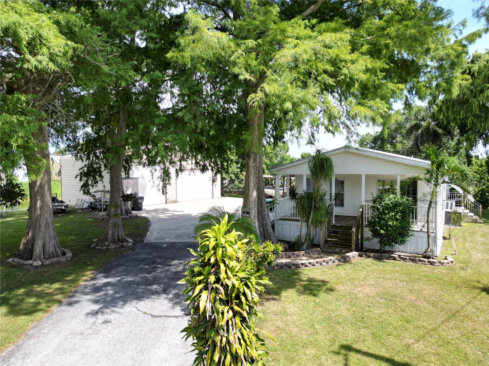 WATERFRONT RETREAT - This 3bd 2ba, 2007 doublewide manufactured home sits at the end of a quiet street with almost 200ft of canal frontage on two sides of the property. The 40x30 metal garage offers ample space for an RV, boat, and/or workshop. Outdoor features include a covered waterfront deck for fishing and relaxation, carport, aluminum wheelchair ramp, canal-fed irrigation, 2 covered porches, and outdoor shower for cleaning up after a day on the water. Inside, the home is sold fully furnished including all major appliances(washer, dryer, chest freezer as well). Set on city water and septic, the lot features beautiful cypress trees and a mature avocado tree providing lots of shade. With direct Lake Okeechobee access, bring your boat and enjoy true Florida waterfront living! All measurements are approximate.