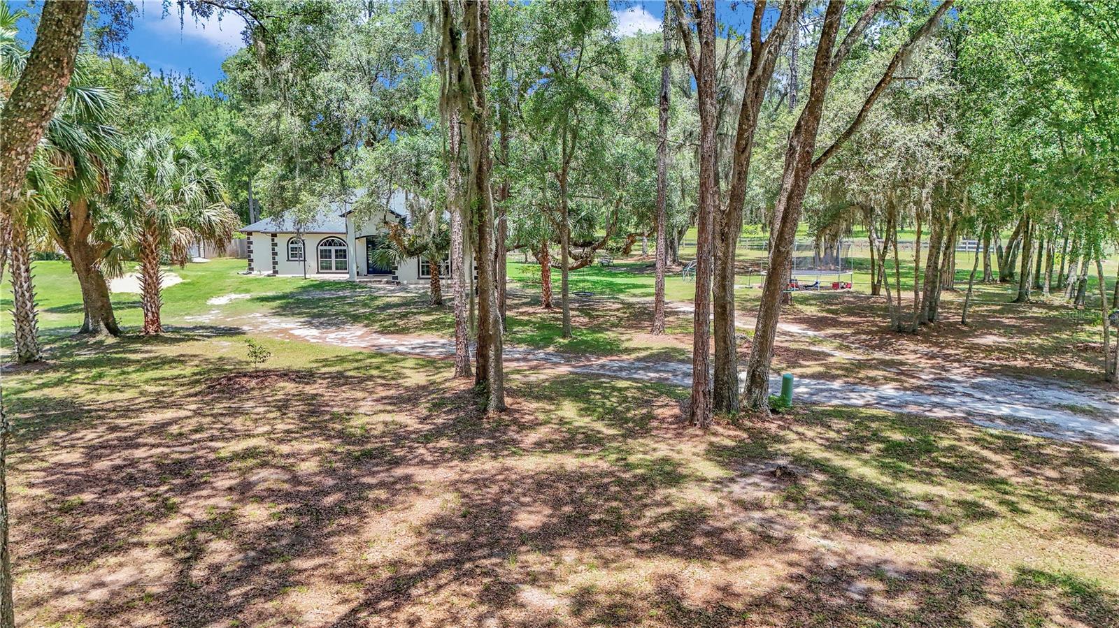 This gated, 4 acre secluded property sits perfectly at the end of a dead-end street! With views of horse farms on 2 sides and forest on the others offering a tranquil view from every angle! A homesteaders dream! This property is zoned A1 for horses and other animals with the whole property being perimeter fenced with no climb and wood. Close to the ATV trailhead, Hog Waller, Lake Kerr, and 90 minutes to the Atlantic Ocean or Gulf Coast! This completely renovated home has all of the modern upgrades you’ve been looking for. This spacious 3 bedroom 2 bath home features new interior and exterior paint, 23 roof, 23 air condition, 24 tankless hot water heater, 23 new whole house water filter and softener, 23 new impact windows and the drainfield was replaced in 22, 23 All the electrical was updated and new fans and lights installed in every room! Complete with 250 gallon gas, propane tank and generator transfer.
Step inside your spacious new home with large 18in tile throughout, a living room with crown molding, tall arched windows and a gas fireplace that seamlessly transition to the kitchen with Stone countertops, solid oak cabinets, backsplash, new range and dishwasher, walk in pantry and a bar top overlooking the dining area with amazing views. To the left of the dining area is the oversized primary bedroom with tray ceilings, bamboo flooring and a large walk-in closet. The huge primary bathroom boasts a garden tub and separate tile surround shower. For your convenience the laundry room is located just off of the primary. Stepping across the home to the split floor plan are the second and third bedrooms, one with a large walk-in closet. The second bathroom is a jack n jill with combo tub/shower that is tile with separate vanities. Step outside through the French doors to the covered and enclosed lanai with views of the backyard filled with majestic Oaks, your own chicken coop with chickens, ducks and geese to stay and provide plenty of eggs! In the over 2400ft² fenced garden are more than 100 plants meticulously planted in order to maximize yield are strawberries, blackberries, blueberries, a variety of vegetables, herbs and more. There are also two other garden plots ready to be planted totaling over 1,000 ft². There are over 50 fruit trees planted on the property as well, including a variety of citrus, apple, plum, peach, cherry, walnut, persimmons, figs, chestnuts, olives and more! There is a perfectly positioned fire pit, matching dog house and well house. The recently updated well house is near the garden for irrigation. As you enter the gate of the property to the left, you are greeted with a 24 x 36 x 14 RV carport with storage and a 200 amp separate meter. Additionally, there is a 12 x 24 garage storage shed near the home with power. This amazing property is completed with a custom treehouse that is two stories tall and sure to bring joy to any family! This once in a lifetime opportunity has it all! Close to boating, fishing, riding your four wheelers and enjoying the peaceful way of life! Energy efficient home with power bills monthly under 150\ month and the property tax bill is $ 5500 / year. HOI is $ 1600 / year!