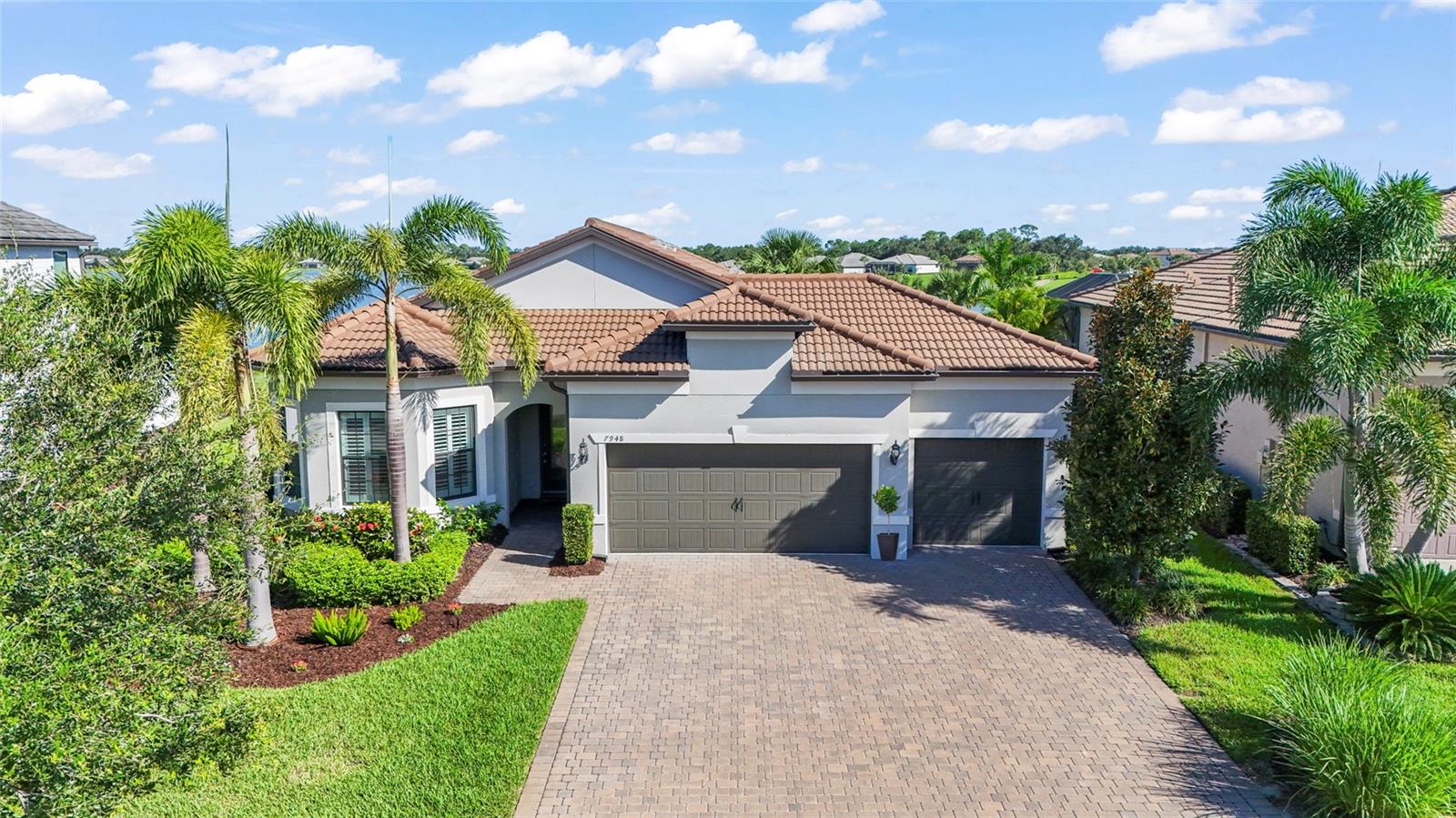 Welcome to luxury living in the sought-after Shoreview at Waterside community! This stunning 3-bedroom, 2-bathroom home offers an exceptional lifestyle with top-tier design elements and captivating water views. Situated on a low-traffic loop with green space across the street and serene water views behind, this residence blends elegance with privacy. Residents enjoy private access to community amenities just across the street in an exclusive enclave.
Step inside to find wood-look tile flooring, plantation shutters, and coffered ceilings that add both style and warmth. The spacious primary suite features a custom walk-in closet and a spa-like en-suite bath with dual vanities. A private den/office provides the perfect work-from-home space.
The chef’s kitchen impresses with quartz countertops, a KitchenAid stainless-steel appliance suite, gas range, and an arched entryway that opens to the family and dining areas. Enjoy a built-in dry bar and wine station with custom cabinetry, perfect for entertaining. The bump-out family room is anchored by a three-sided fireplace, adding ambiance to multiple spaces.
Outdoor living shines with a fully equipped summer kitchen featuring a granite backsplash and stainless-steel countertops, a gas hookup, outdoor hood, and plenty of room to relax or entertain. The 3-car garage with an oversized bay and paver driveway offer both function and curb appeal.
Additional highlights include laundry room built-ins, wiring and gas line installed for a future whole-house generator.
Don’t miss your opportunity to own this beautifully appointed home in one of Lakewood Ranch’s premier communities.