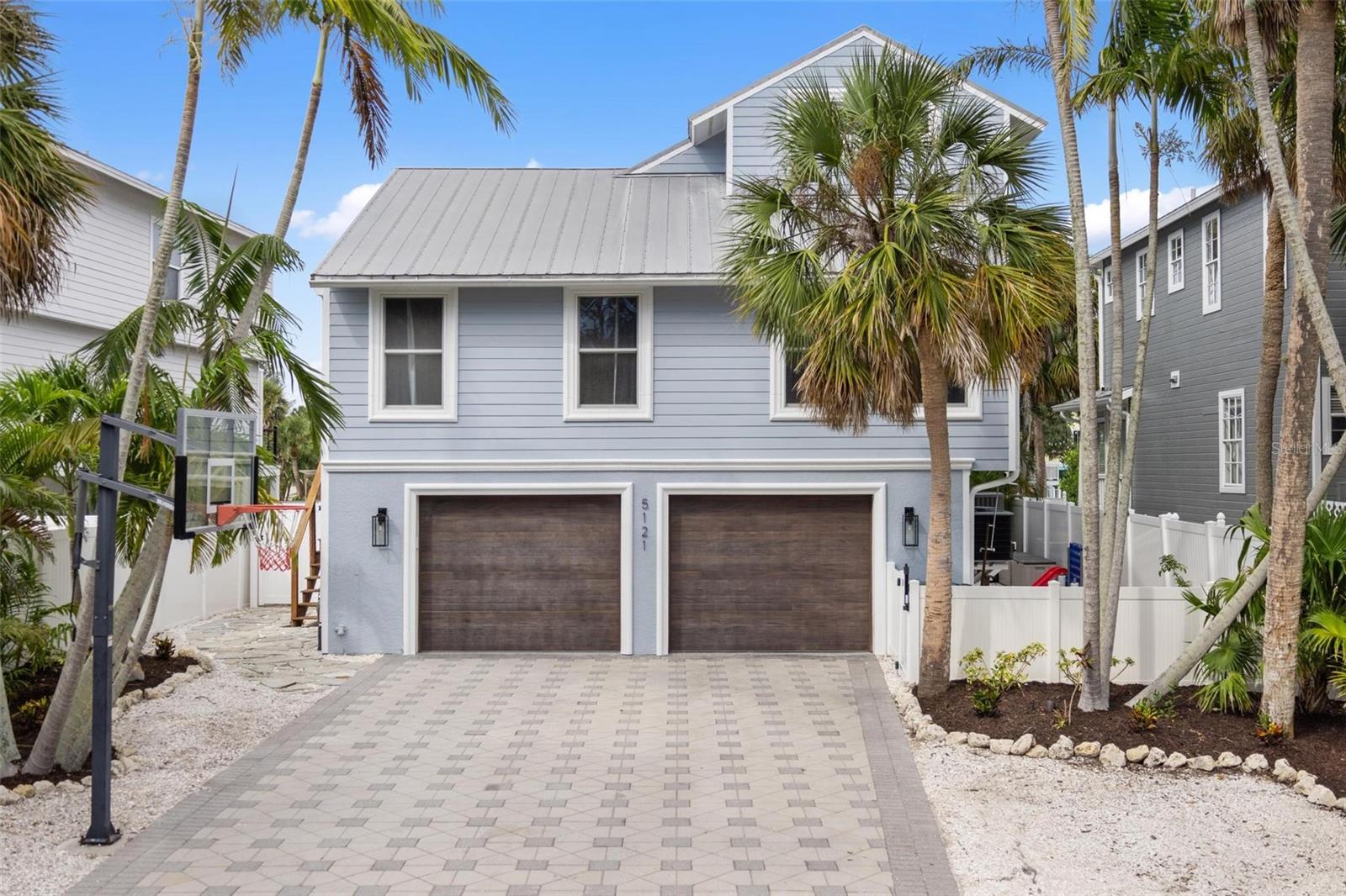 Under contract-accepting backup offers. Just minutes from the powdery white sands of Siesta Beach and the vibrant energy of Siesta Key Village, yet tucked away on a quiet, oak-shaded street, 5121 Oxford Drive is a 3-bedroom, 3-bath waterfront pool home with a surprise bonus: in addition to its 2,270 sq. ft. of conforming space, the ground level offers another 650 SF+ of fully finished, non-conforming space. This area could include an additional bedroom (4th) and bonus room, perfect for guests, in-laws, extended family, or added rental income potential, making the property far more versatile than most homes in its class. Located on the coveted Grand Canal, with 50 feet of deep-water frontage, you’ll be on the bay in just minutes. A brand-new dock and 10,000 lb. lift (2025) are ready for your boat, and the property is golf cart–friendly, allowing you to cruise easily to the Village or beach. For the right buyer, furnishings, the golf cart, and even the boat are negotiable, creating a truly turnkey opportunity. Every major upgrade has been completed so you can enjoy the home from day one. Impact-rated low-e sliders and exterior doors (2025) fill the space with natural light and security. The durable metal roof is built to last, while all-new HVAC systems (2025), a whole-home dehumidifier (2025), and a tankless water heater (2023) ensure modern comfort. The garage features hurricane-rated insulated doors (2020), a mini-split A/C (2025), and epoxy flooring (2025)—perfect for keeping your toys protected in style. The gourmet kitchen, fully renovated in 2023, boasts quartz counters, high-end stainless steel appliances, custom solid wood cabinetry and a sleek coastal design. The master bath (2024) feels like a spa retreat, and even the fireplace area was refreshed in 2021, adding a warm focal point to the living space. The living area flows onto wraparound balconies made from Cumaru Brazilian teak, overlooking the sparkling new saltwater pool (2024) with electric heater, marble travertine pavers, and all-new equipment. This property is made for the lifestyle you’ve been dreaming about - morning coffee as boats glide by, afternoons on the water, and evenings walking or taking the golf cart to dinner in the Village. Whether you’re seeking a full-time residence, a vacation getaway, or a high-demand rental, 5121 Oxford Drive delivers it all - turnkey option, fully upgraded, and ready for you to enjoy.