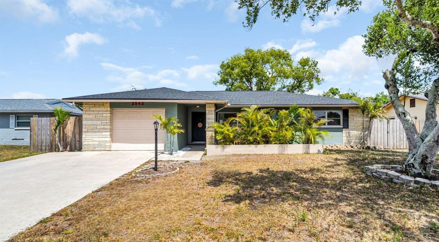 Gorgeous 2-bedroom, 2-bath home featuring an updated, open, light and bright floor plan! From the moment you step inside, you’re welcomed by an abundance of natural light, stunning luxury vinyl plank flooring throughout, and a show-stopping kitchen that opens seamlessly to the main living space. The kitchen is truly the heart of the home, boasting a massive island with granite countertops, updated cabinetry, stainless appliances, a butcher block accent counter, and a prime location between the living/dining room combination and a versatile bonus room. Both bedrooms are generously sized, with the primary suite offering an en-suite bath complete with a walk-in shower and dual built-in cabinets. Sliding glass doors lead to a covered back patio overlooking an oversized, fully fenced backyard with double gates—perfect for storing boats, trailers, or other toys. The widened driveway provides ample parking for multiple vehicles leaving plenty of room to spare. Major updates include a BRAND-NEW (2026) ROOF, (2021) hot water heater, and (2016) HVAC system. Located in a high and dry NON-FLOOD zone, this home is just minutes from Dunedin, Honeymoon and Caladesi Islands. Community amenities INCLUDE a pool, clubhouse, shuffleboard courts, and a fitness room, all with a low HOA fee. Enjoy easy access to Clearwater and Dunedin beaches, shopping, dining, and the vibrant downtown Dunedin area. Tampa International Airport is approximately 30 minutes away. Move-in ready and perfect as a primary residence or seasonal retreat—don't wait, this opportunity won't last long. Call TODAY!