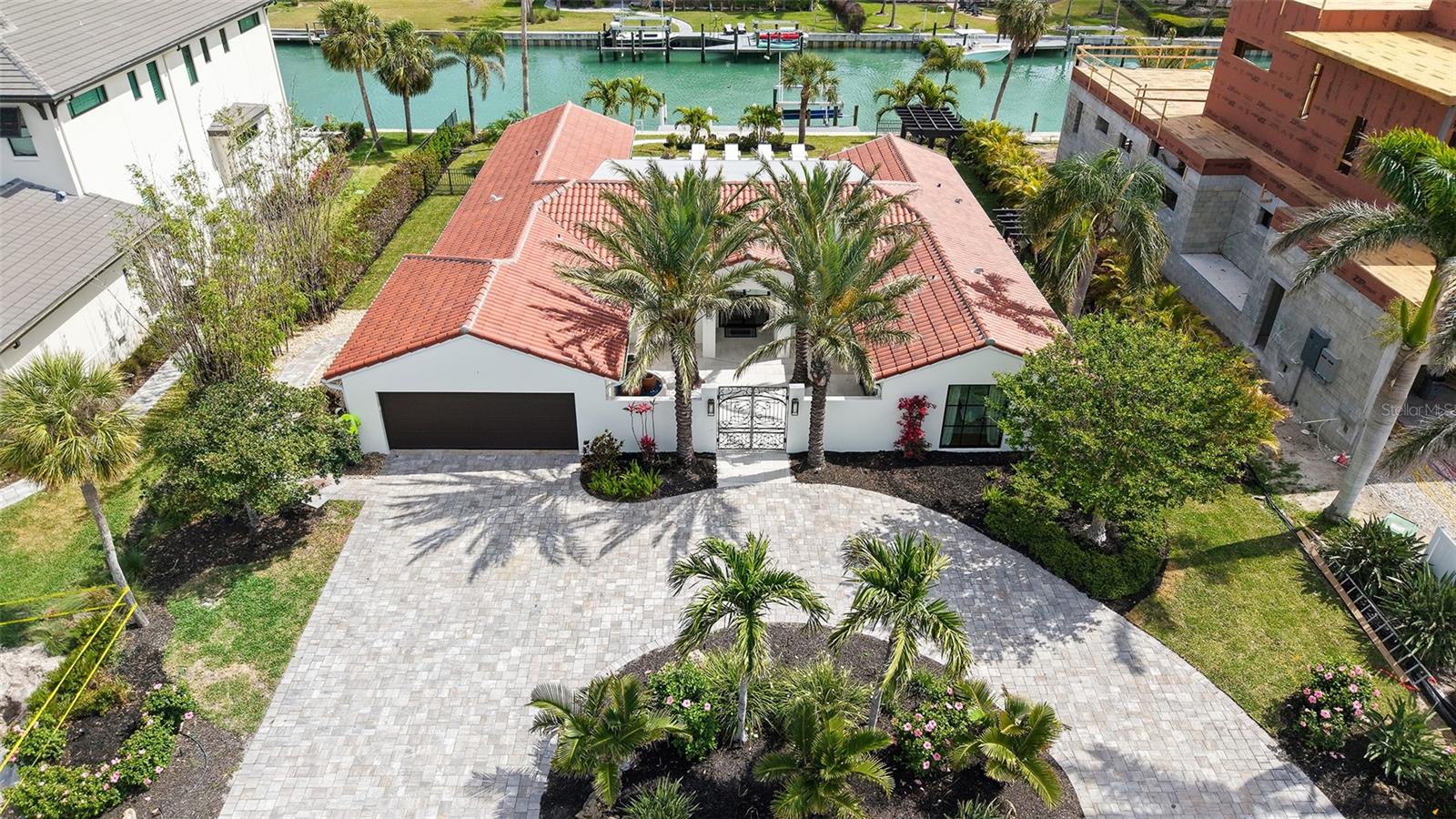Tropical Florida living is epitomized by glamorous finishes, superior comfort and exceptional quality throughout this stunningly renovated residence. Once inside, an updated focal wall in the great room features custom white oak shelves and an electric fireplace creating a dramatic first impression. Fresh paint, custom wood beams, all new imported Mirage wood floors, and stunning new lighting enhance this flowing floor plan, where natural light cascades over spacious rooms designed for gorgeous entertaining and everyday moments. A defining focal point, the gourmet kitchen features white oak accents, updated quartzite countertops, a stunning Wolf range, Wolf double ovens and a Sub Zero wine fridge. A custom door assembled to match the cabinetry opens from the kitchen into a spacious pantry and laundry room. Perfectly detailed, the primary bedroom is a haven of serenity with a newly-tiled designer bathroom and easy access to the lanai for sipping your morning latte. The resort-worthy pool area will transport you to a paradise of relaxation, with ample new space for sun lounging. Completing this amazing property is a new tile roof, new ES impact rated sliding glass doors, a 2-car garage with updated door, opener and Epoxy flooring, new landscaping, an updated seawall, and a well water system upgraded with sprinklers. This home is truly like new, and presents a lifestyle without compare just moments from downtown Sarasota and St. Armands.