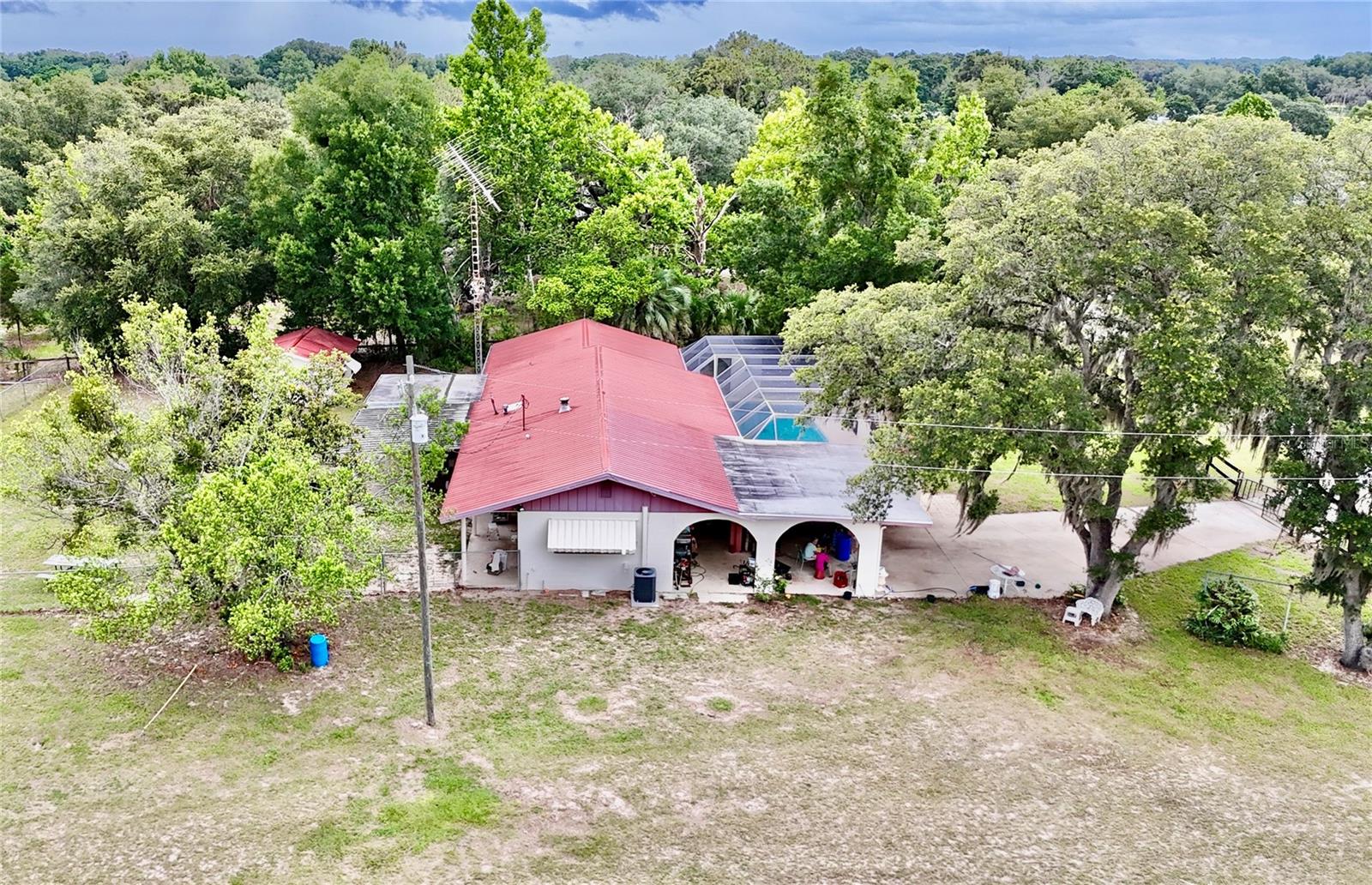 Beautiful 3/3 Pool Home with easy access.  Less than 10 Miles from 75 exit here is a beautiful piece of land that is gorgeous - 8 plus high and dry acres  with mature Live Oaks in Summerfield/Pedro.  Old style Spanish flair with a unique open floor plan. This one has loads of potential in horse country with a nice 6 stall horse barn and additional 3 stall, storage equipment building water to all paddocks. Fenced back yard with shed for storage. Solid block home with metal roof and concrete pool and screened  enclosure.   Newer 4 ton AC, Water Heater, Pump and Well. Screened  Pool is large and in working order.   Endless potential -Bring the family, bring the horses make this your home today!  Call for showing appointment!