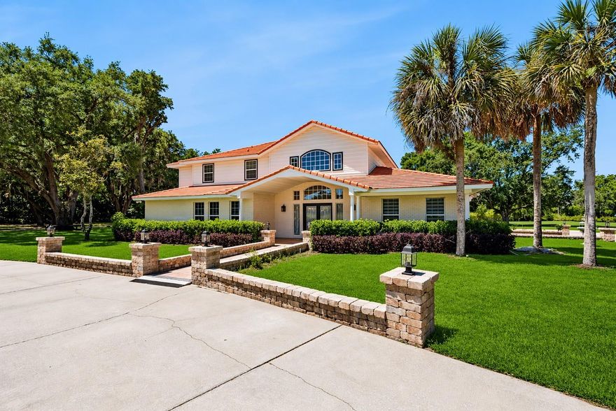 One or more photo(s) has been virtually staged. A rare opportunity to acquire a truly versatile estate offering 7,600+ square feet of combined interior space set on 5.26 fully usable acres, privately gated and designed to accommodate a wide range of residential, institutional, and community-oriented uses.  Thoughtfully improved and exceptionally maintained, this expansive property features up to 8 bedrooms and 9 bathrooms (both main house and detached guest building, multiple dedicated office rooms, flex spaces, gathering & entertaining rooms, and a highly functional layout that supports both large-scale occupancy and flexible use configurations.  
This property offers exceptional flexibility for a variety of permitted and adaptive uses, including: Private school or educational campus; Daycare or early learning facility; Church, ministry, or religious assembly use; Group home or assisted living style residence (subject to approvals); Community center or nonprofit operations; Agricultural-support or small-scale commercial/agri-related functions; Multi-family or extended residential estate use.  Its scale, layout, and infrastructure support both quiet residential living and higher-capacity organizational uses.  
Inside, the estate is designed to function seamlessly across multiple potential use types, including:  Multiple private office rooms ideal for administrative or instructional use; Two fully equipped kitchens supporting large-group operations or meal service; A spacious dining hall suitable for gatherings, instruction, or communal dining; Dedicated event or assembly room with open flexible space; Ample storage rooms throughout for operational support and organization; Well-distributed bedroom and bathroom layout allowing for structured occupancy.  The interior configuration provides exceptional adaptability for institutional, residential, or community-based use.  Set within a fully fenced and gated 5.26-acre parcel, the exterior offers a private and secure environment with extensive usable land, including:  Large outdoor gathering and activity areas; Covered outdoor kitchen designed for group service and entertaining; Expansive open lawn areas suitable for recreation, programming, or events; Mature natural surroundings providing privacy and a campus-like setting; Secure gated entry with controlled access.  The exterior grounds provide a peaceful, campus-style atmosphere well-suited for private events, structured programming or community-focused operations.
With its combination of size, privacy, multiple structures within a single residence footprint, and fully usable acreage, this estate represents a rare opportunity for buyers seeking a property that can evolve with their vision—whether residential, institutional, or community-focused.  Privately gated and ideally configured, it offers both immediate usability and long-term adaptability in one of Central Florida’s most desirable estate corridors.  Call today to schedule a private viewing.