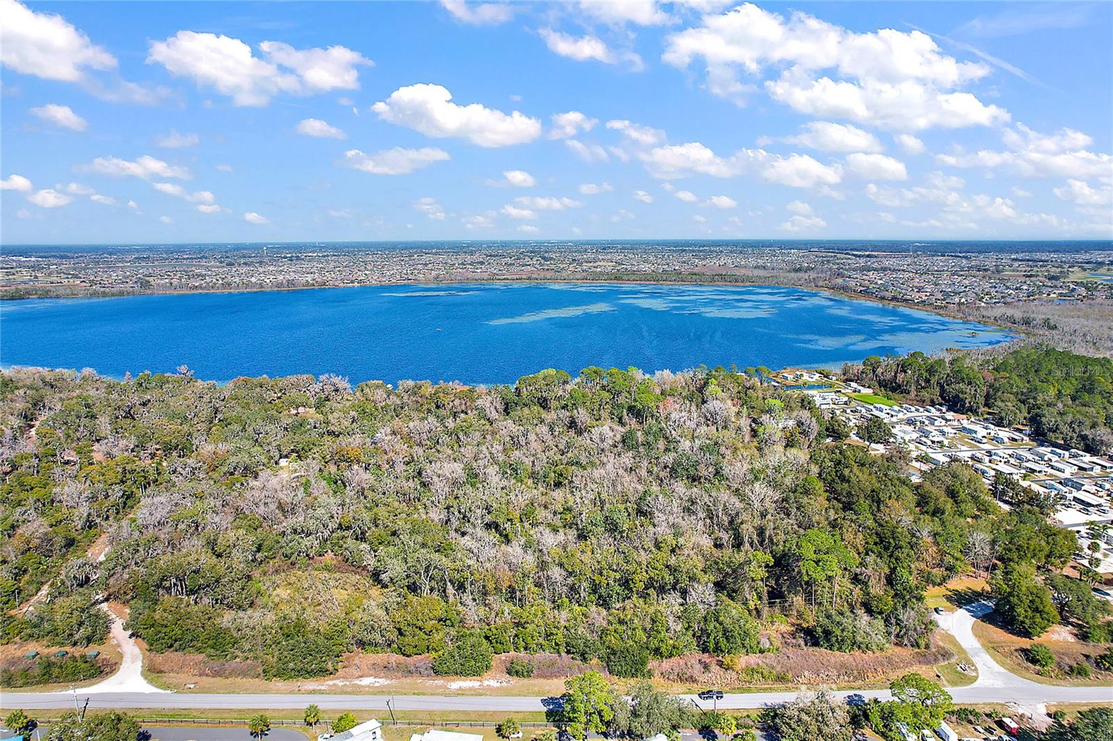 17.5 wooded acres of direct lakefront property on the pristine Lake Deaton. This is a rare opportunity to purchase this large of a parcel directly on an approximately 500 acre Lake. This offering is for two parcels, Sumter County ID: G23-050 and G23-022, currently zoned RR5 within Sumter County. The adjacent property is zoned R2M, so one may assume the same zoning could be assigned to these two parcels. Upon rezoning, the property could yield seven lakefront lots at almost 80' wide, then with roads and drainage, the remaining land could possibly be divided into 18 interior one half acre lots, see concept site plan in listing, this is a concept only and has not been approved. Imagine the potential that this type of development could have with its close proximity to hospitals, medical plazas, shopping, The Villages, and so much more. This could be the next exclusive address. Or, it may be possible to seek proper zoning for a lakefront RV park, use your imagination and take advantage of this offering. There is an old mobile home, barn, and well on site, but the land is the value. All information provided is assumed to be accurate but must be confirmed by the buyer.